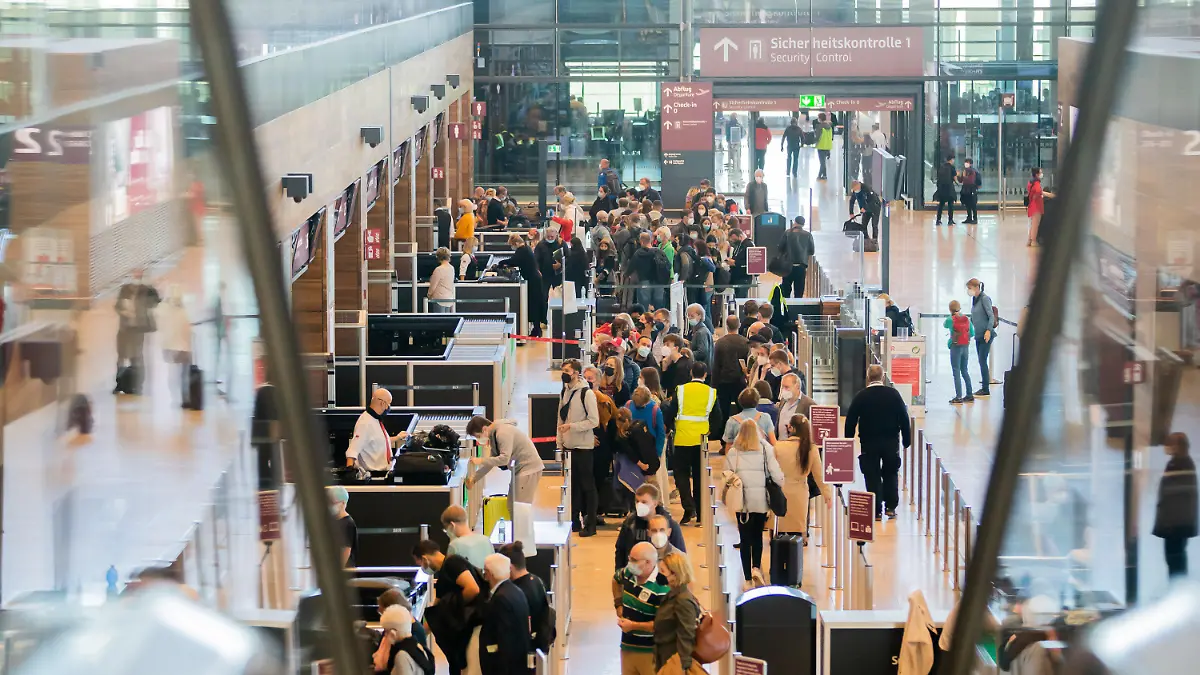 09.10.2021, Brandenburg, Schönefeld: Zahlreiche Passagiere stehen am Hauptstadtflughafen Berlin Brandenburg «Willy Brandt» (BER) im Terminal 1 vor der Sicherheitskontrolle Schlange. (Kein Ausschnitt) Foto: Christoph Soeder/dpa +++ dpa-Bildfunk +++