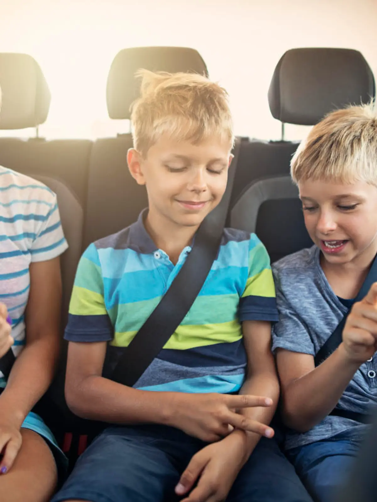 Three kids playing rock paper scissors in car on a road trip. Kids are aged 12 and 9. The kids are laughing and having fun. Sunny summer day.
Nikon D850.