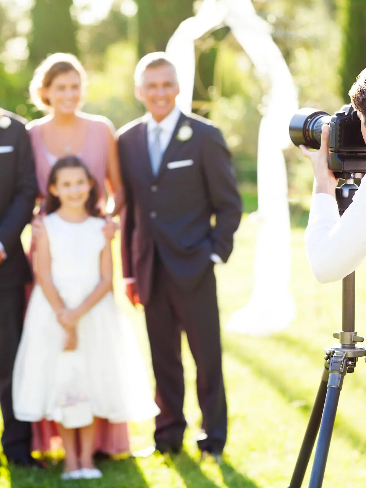Young man photographing family at outdoor wedding. Horizontal shot.