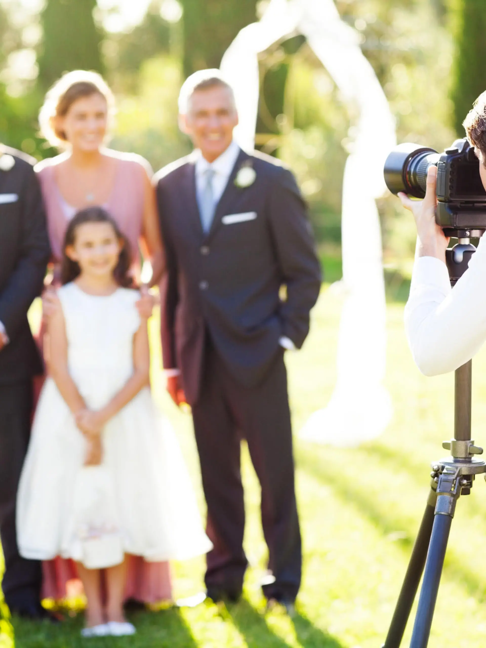 Young man photographing family at outdoor wedding. Horizontal shot.