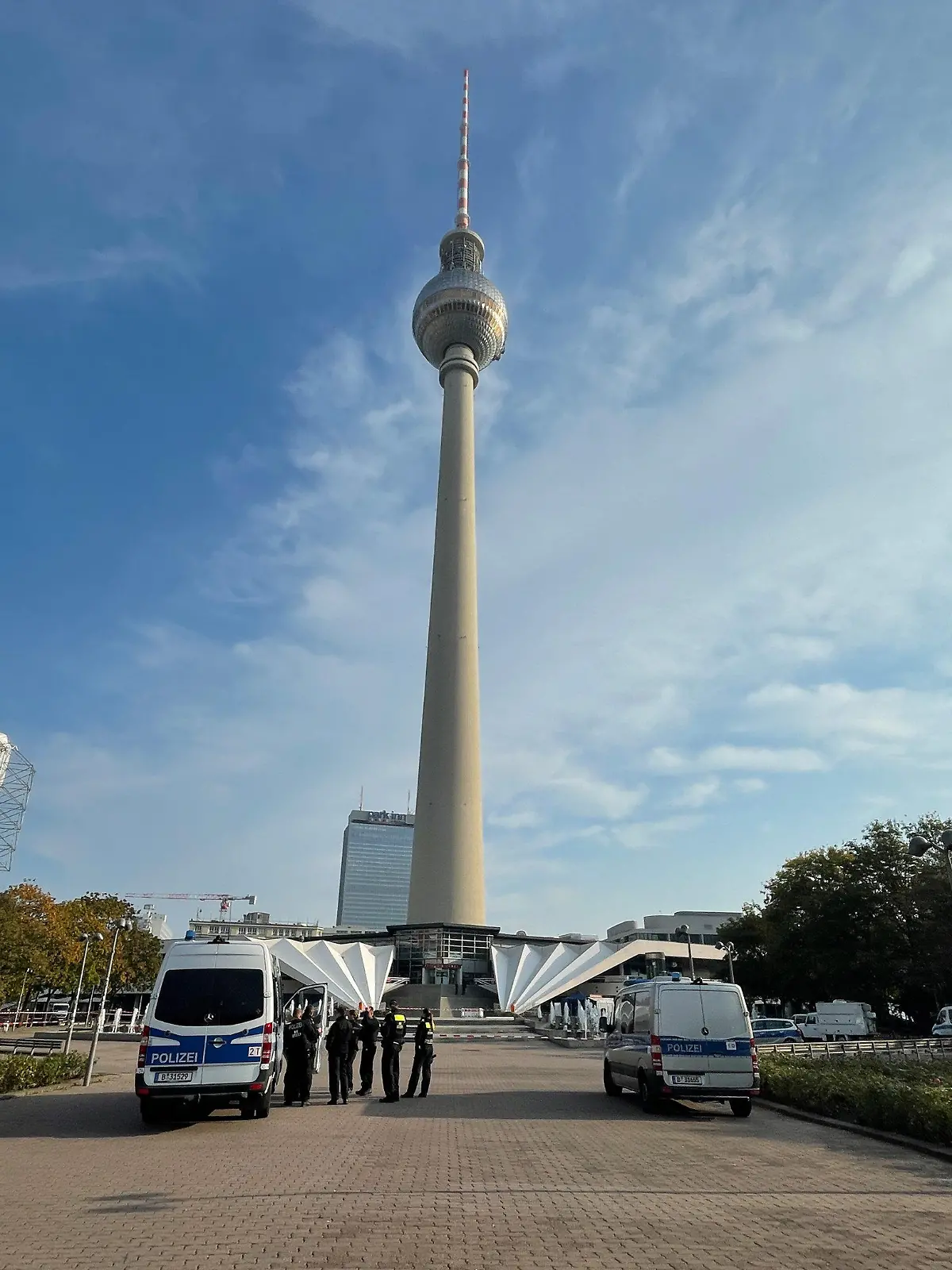 08.10.2021, Berlin: Einsatzfahrzeuge der Polizei stehen auf dem Alexanderplatz unterhalb des Fernsehturms. Dort wurde am Morgen eine Leiche gefunden. Die Polizei geht von einem Verbrechen aus. Eine Mordkommission hat die Ermittlungen aufgenommen. Foto: Paul Zinken/dpa +++ dpa-Bildfunk +++