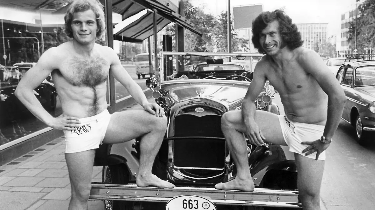 Nicht mehr nackt zu feiern brauchen die beiden Fußballer des  FC Bayern München, Uli Hoeneß und Paul Breitner. Aufnahme vom 5.6.1973. Nach der Vorführung von Bademoden eines Münchner Herrenausstatters bekamen sie die elegantesten Modelle geschenkt. Pressefotos von der Badeparty nach einer Meisterschaftsfeier des FC Bayern München hatten vor einem Monat viel Staub aufgewirbelt.