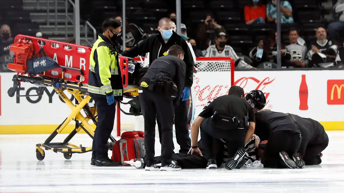 Linesman Ryan Gibbons gets medical attention after an injury prior to the first period of a preseason NHL hockey game between the Los Angeles Kings and the Arizona Coyotes in Los Angeles, Tuesday, Oct. 5, 2021. (AP Photo/Alex Gallardo)