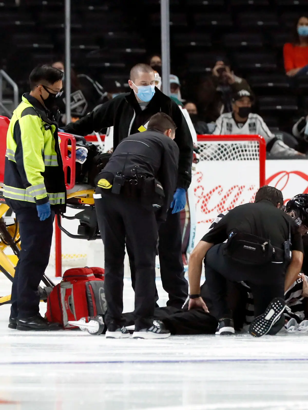 Linesman Ryan Gibbons gets medical attention after an injury prior to the first period of a preseason NHL hockey game between the Los Angeles Kings and the Arizona Coyotes in Los Angeles, Tuesday, Oct. 5, 2021. (AP Photo/Alex Gallardo)