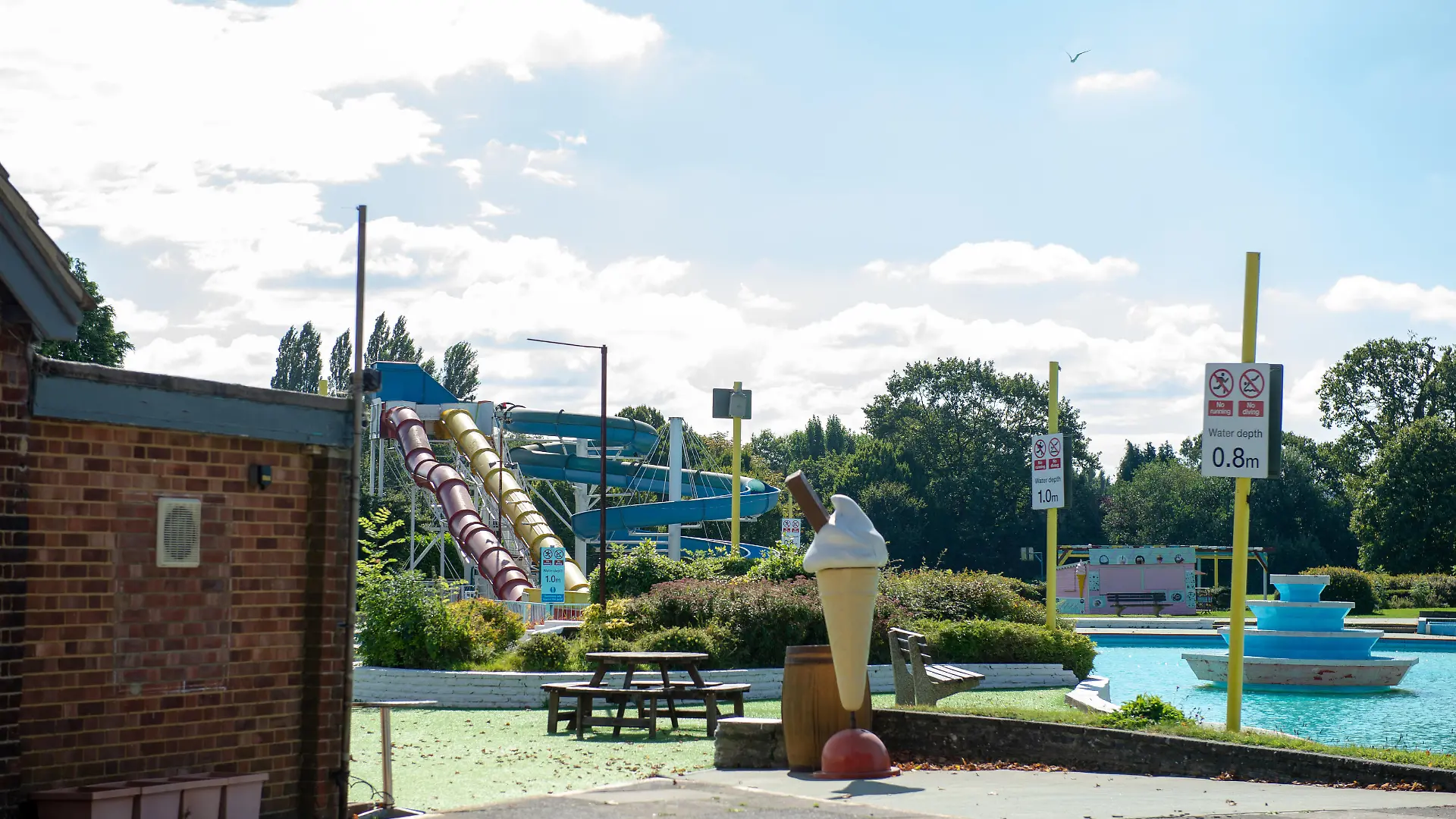 SONDERKONDITIONEN: Satzpreis!
ONLINE EMBARGO 04/10/21 14:00HRS
General view of Aldershot Lido where friends Barry Douglas and Claire Vickers broke their legs going down a closed waterslide(yellow slide). Two friends broke a leg each and badly damaged their feet after they broke into a swimming pool during a drunken night out and went down a water slide. See SWNS story SWSYwaterslide. Grandma-of-two Claire Vickers, 46, and friend Barry Douglas, 44, remained stuck in the flume for two hours with broken shins and shattered feet before they were rescued. The two broke into Aldershot Lido in Hampshire in the early hours of August 4 after a night of drinking, and decided to try and go down the slide. After splashing water down from the top to generate extra speed, Claire and Barry stepped into the tube together, thinking that it was clear all the way down. But just before they came out the bottom, their legs collided with a barrier that had been placed at the exit. They were rescued after police called in to investigate reports of "kids" messing around in the pool.