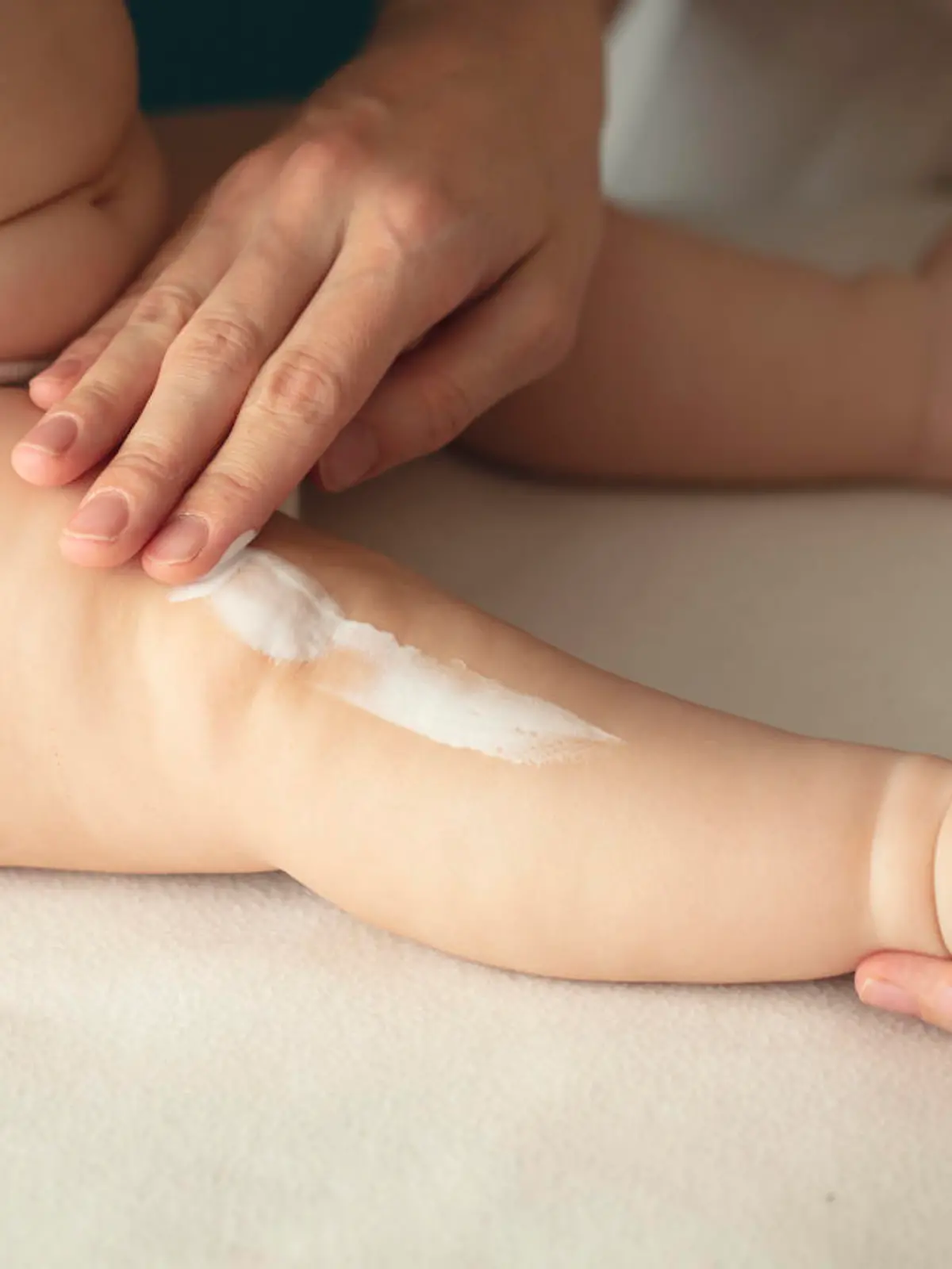 Woman hand holding infant leg. Mother carefully applying medical ointment. Red dry skin allergy from milk formula or other food. Care about baby body. Closeup shot with dslr camera, canon 5dsr