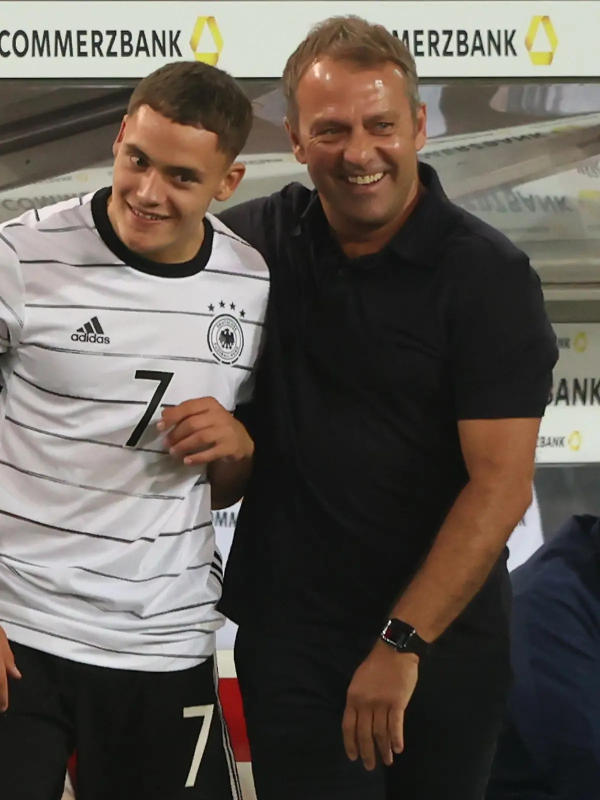 STUTTGART, GERMANY - SEPTEMBER 05: Hans-Dieter Flick, head coach of Germany jokes with his player Florian Wirtz prior to his substitution during the 2022 FIFA World Cup Qualifier match between Germany and Armenia at Mercedes-Benz Arena on September 05, 2021 in Stuttgart, Germany. (Photo by Alexander Hassenstein/Getty Images)