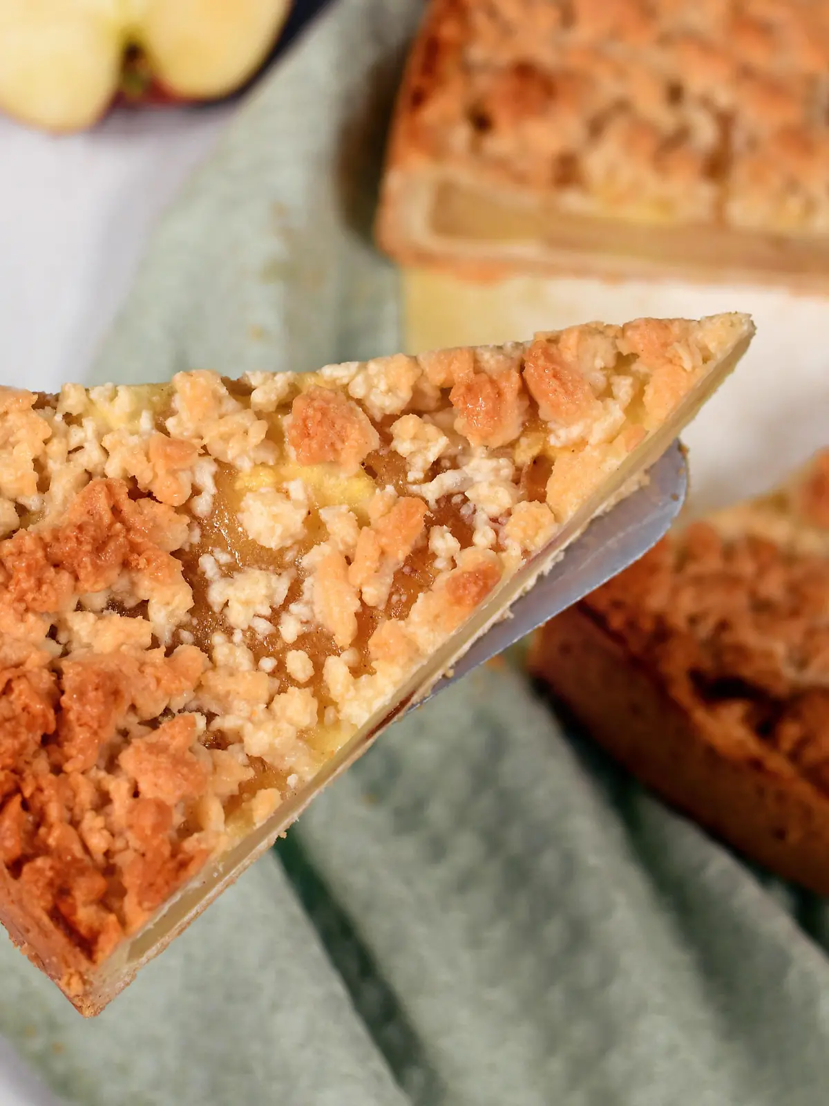 Slice of traditional European apple pie with topping crumbles called 'Streusel' on cake server