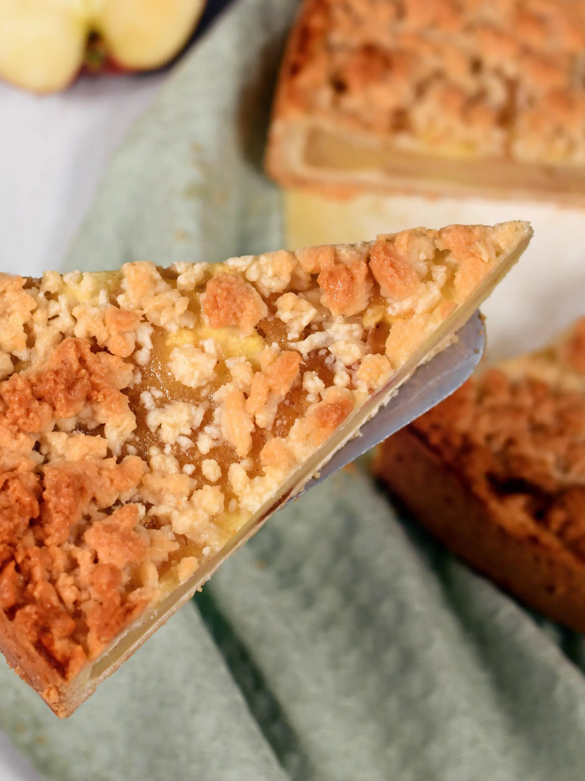 Slice of traditional European apple pie with topping crumbles called 'Streusel' on cake server