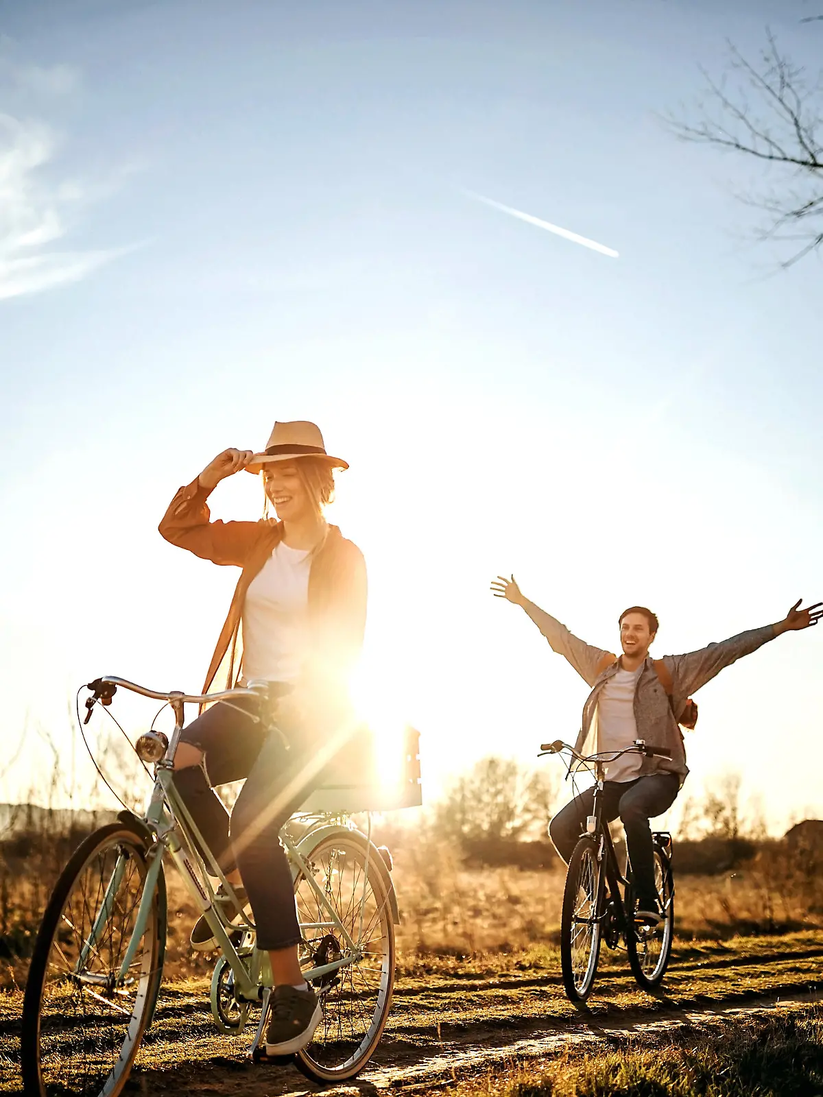 Couple driving on bicycle in nature, enjoying the sun