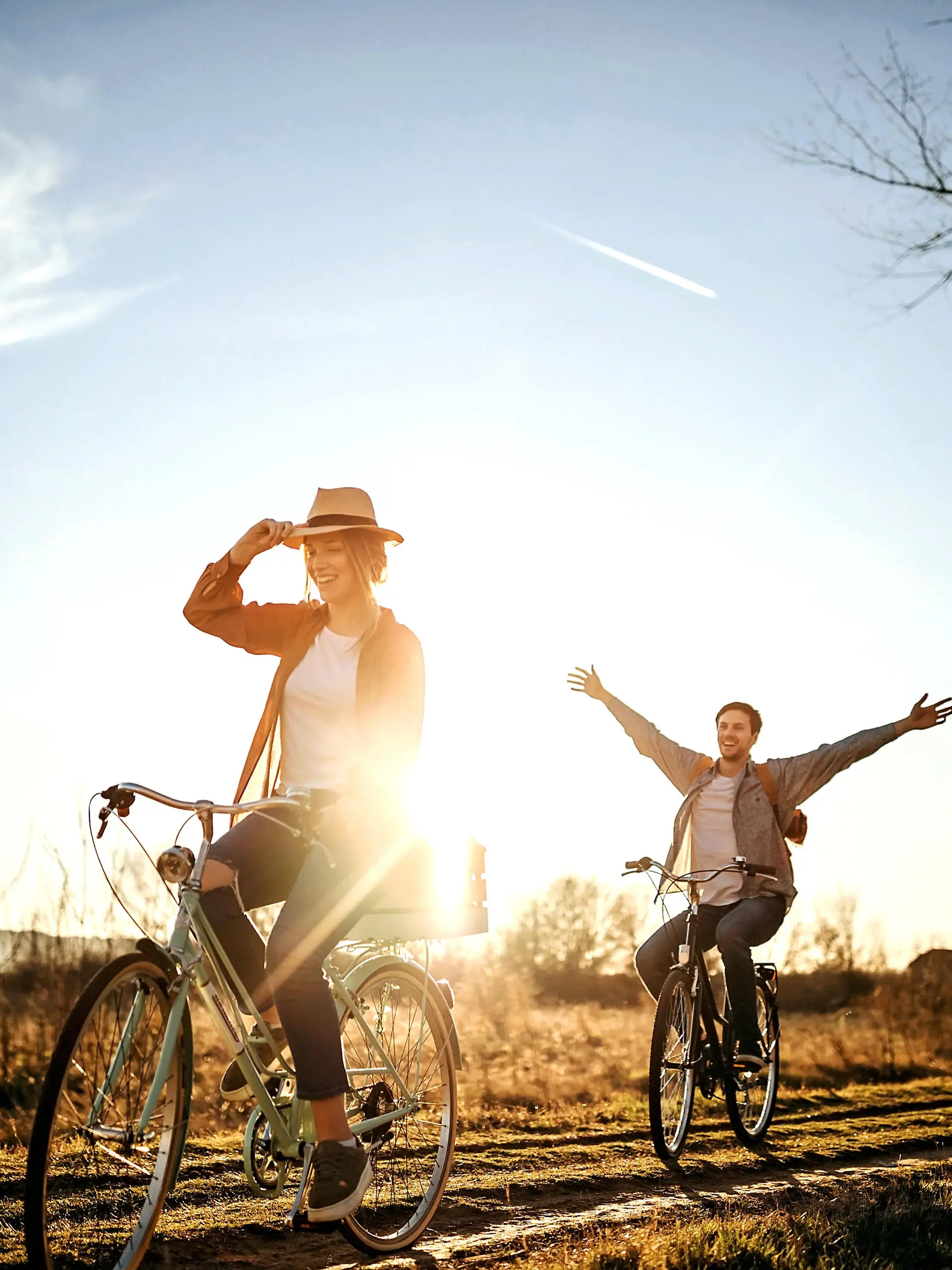 Couple driving on bicycle in nature, enjoying the sun