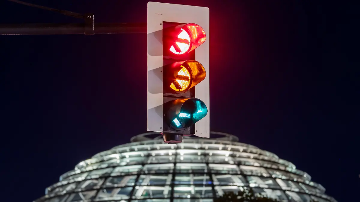 06.10.2021, Berlin: Eine Ampel vor der Kuppel des Reichstagsgebäudes leuchtet in einer Langzeitbelichtung in allen drei Phasen. (Aufnahme mit Langzeitbelichtung) Foto: Christoph Soeder/dpa +++ dpa-Bildfunk +++