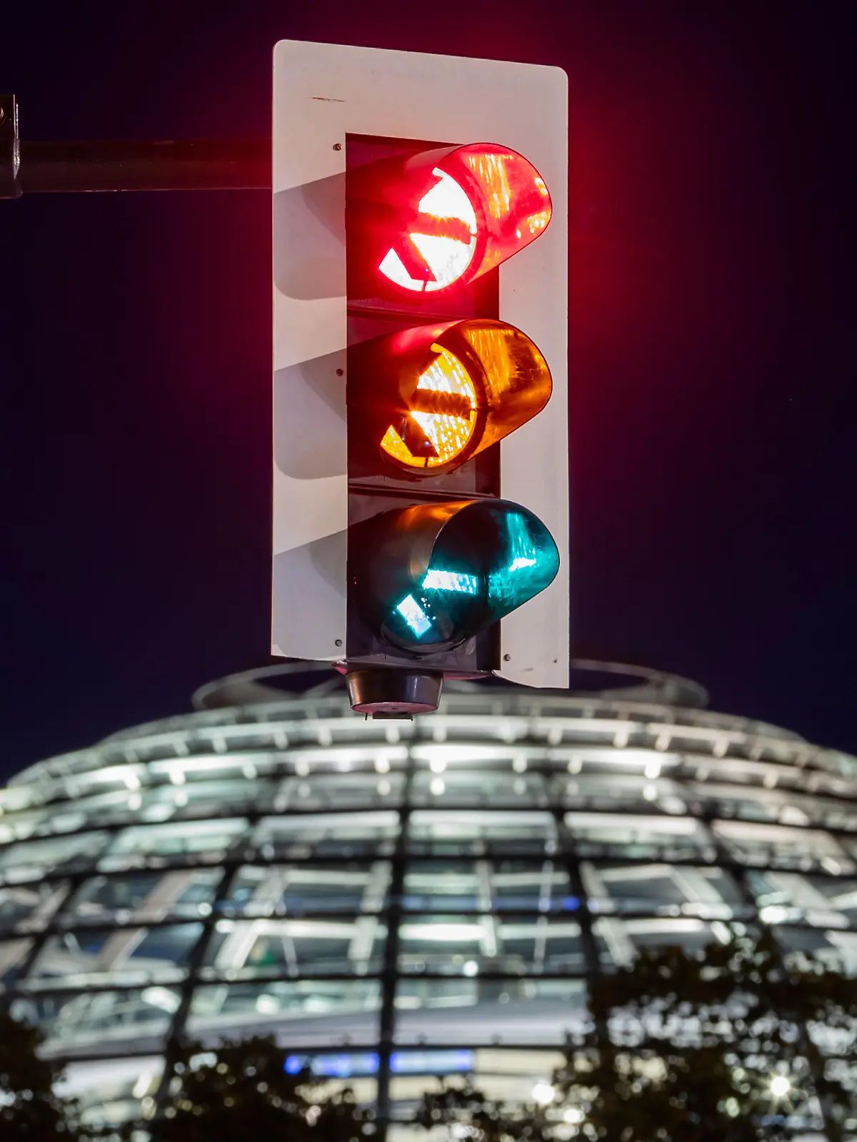 06.10.2021, Berlin: Eine Ampel vor der Kuppel des Reichstagsgebäudes leuchtet in einer Langzeitbelichtung in allen drei Phasen. (Aufnahme mit Langzeitbelichtung) Foto: Christoph Soeder/dpa +++ dpa-Bildfunk +++