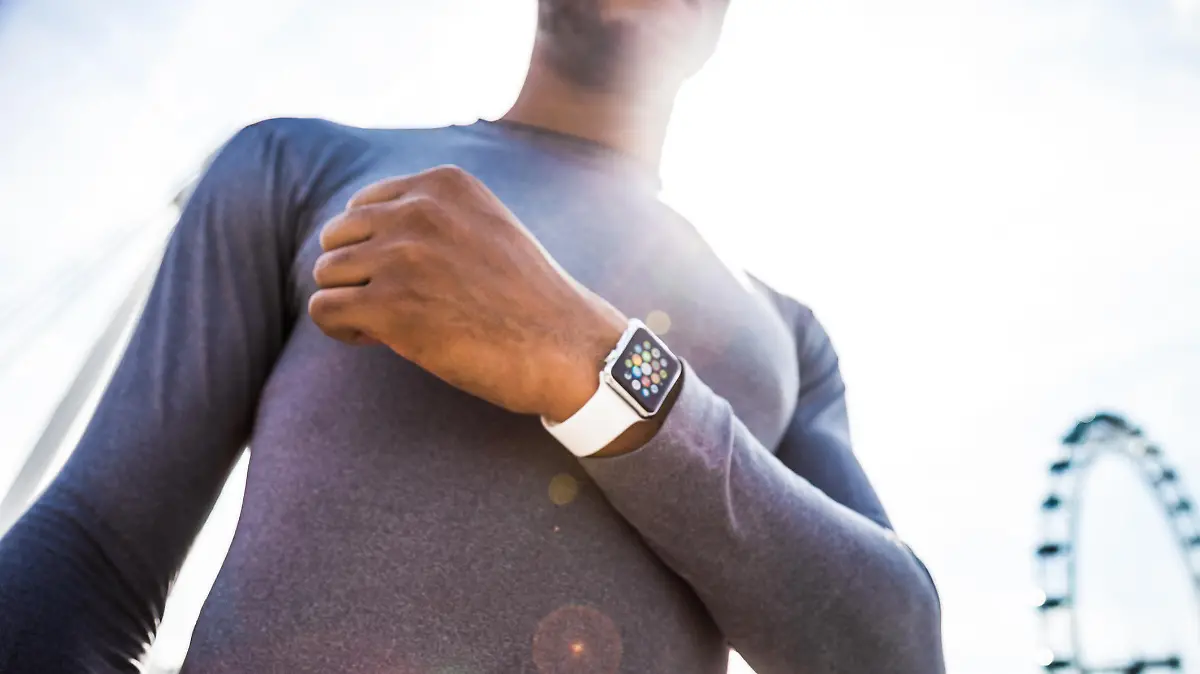 London, United Kingdom - September 7, 2015: Healthy man wearing a 38mm stainless steel Apple Watch with white sports band close to London Eye before the start of a run.