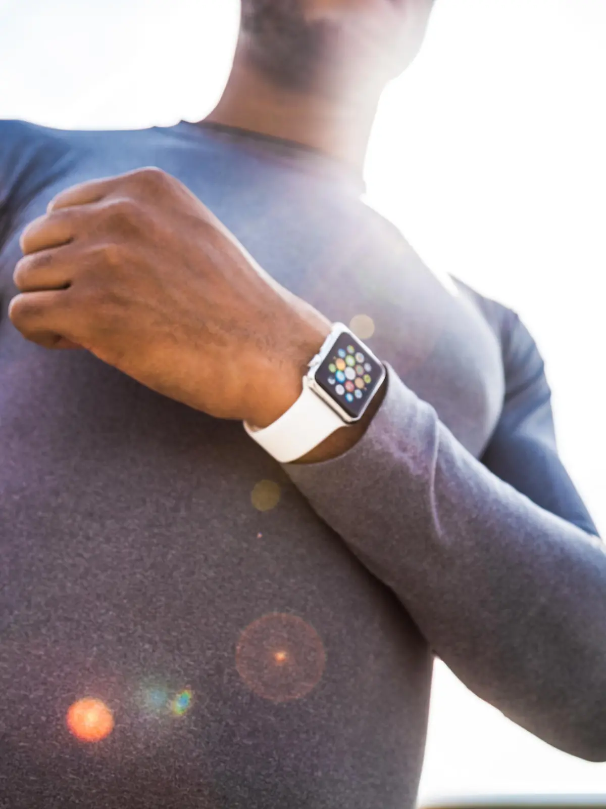 London, United Kingdom - September 7, 2015: Healthy man wearing a 38mm stainless steel Apple Watch with white sports band close to London Eye before the start of a run.