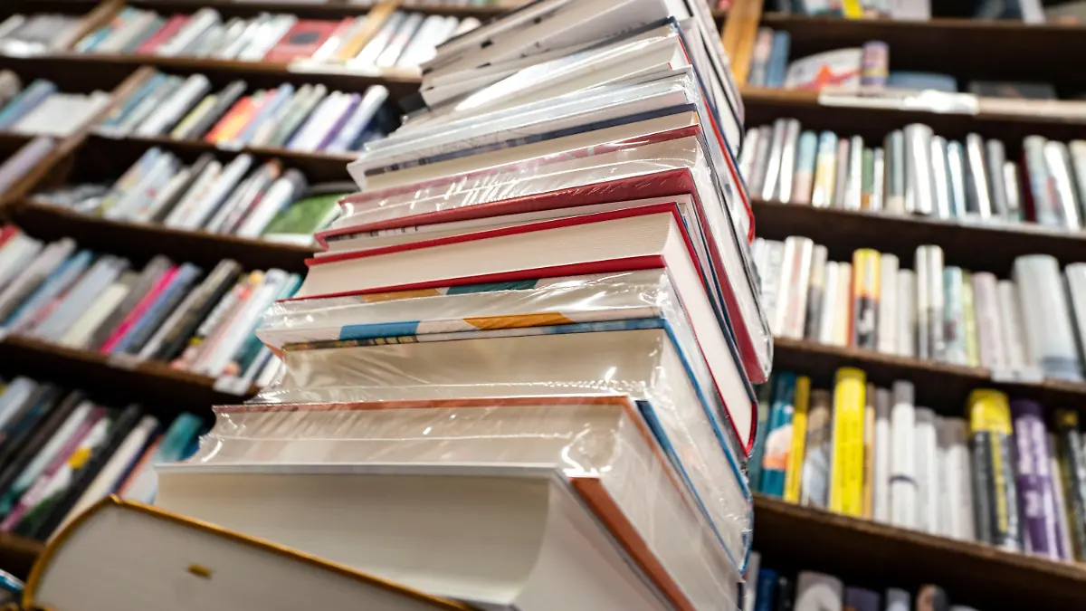 ARCHIV - 17.08.2020, Hessen, Frankfurt/Main: Ein Stapel neuer Bücher liegt auf einem Verkaufstisch in einer Buchhandlung im Stadtteil Bornheim. Im Trend: Radeln, Wandern, Kochen, Kinderbücher. Die Corona-Epidemie hat spürbaren Einfluss auf die Buchkäufe in Deutschland, wie Buchgroß- und -einzelhändler berichten. (zu dpa «Kochbuch top, Reiseführer flop - Corona beeinflusst Buchmarkt») Foto: Frank Rumpenhorst/dpa +++ dpa-Bildfunk +++