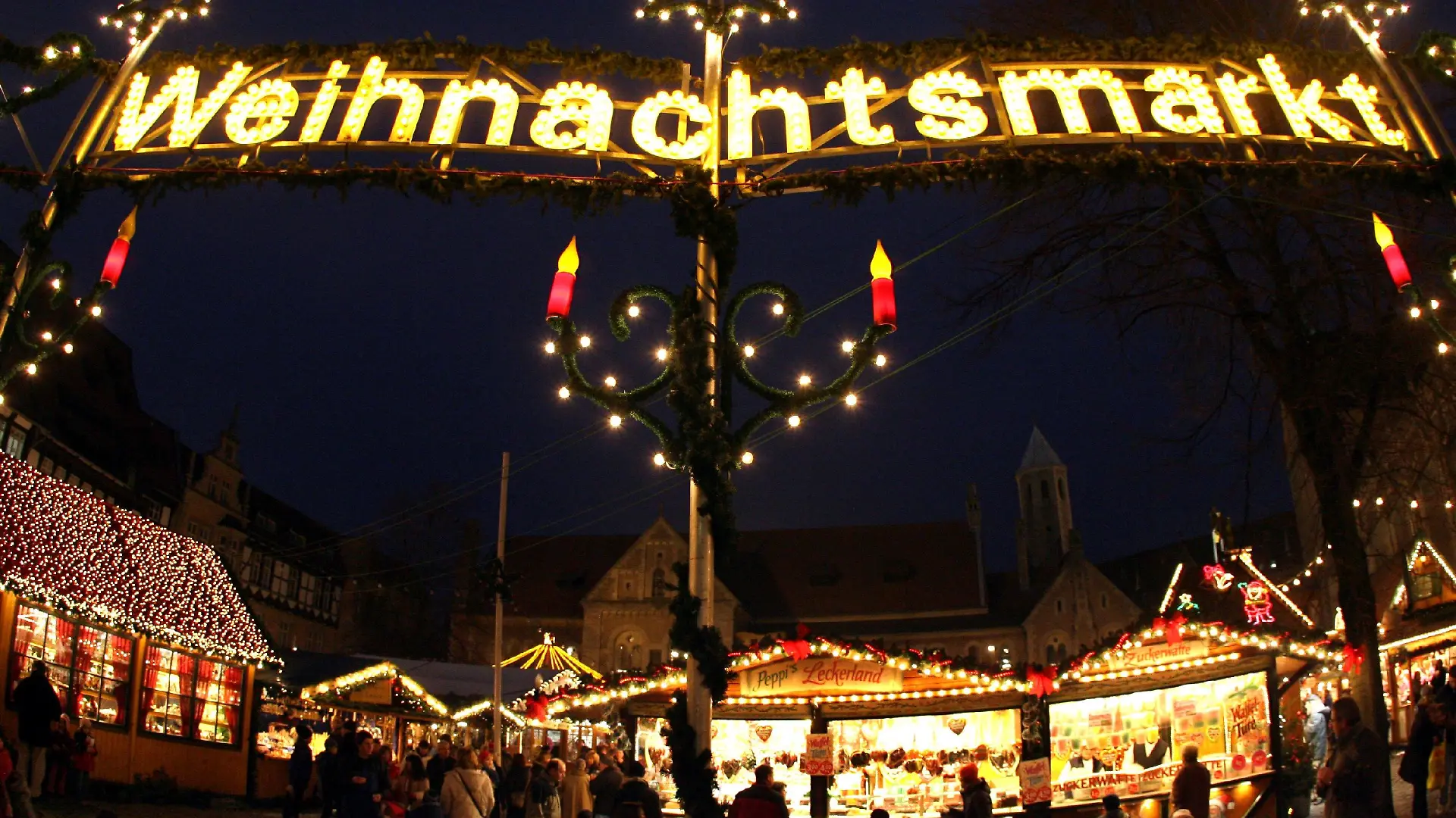 Besucher gehen am Dienstag (18.12.2007) vor der Kulisse des mittelalterlich geprägten Burgplatzes über den traditionellen Weihnachtsmarkt in Braunschweig. Mehr als 130 geschmückte Marktstände laden dort rund um den Dom Heinrichs des Löwen bis zum 28. Dezember 2007 zum weihnachtlichen Bummel ein. Foto: Holger Hollemann dpa/lni +++(c) dpa - Bildfunk+++