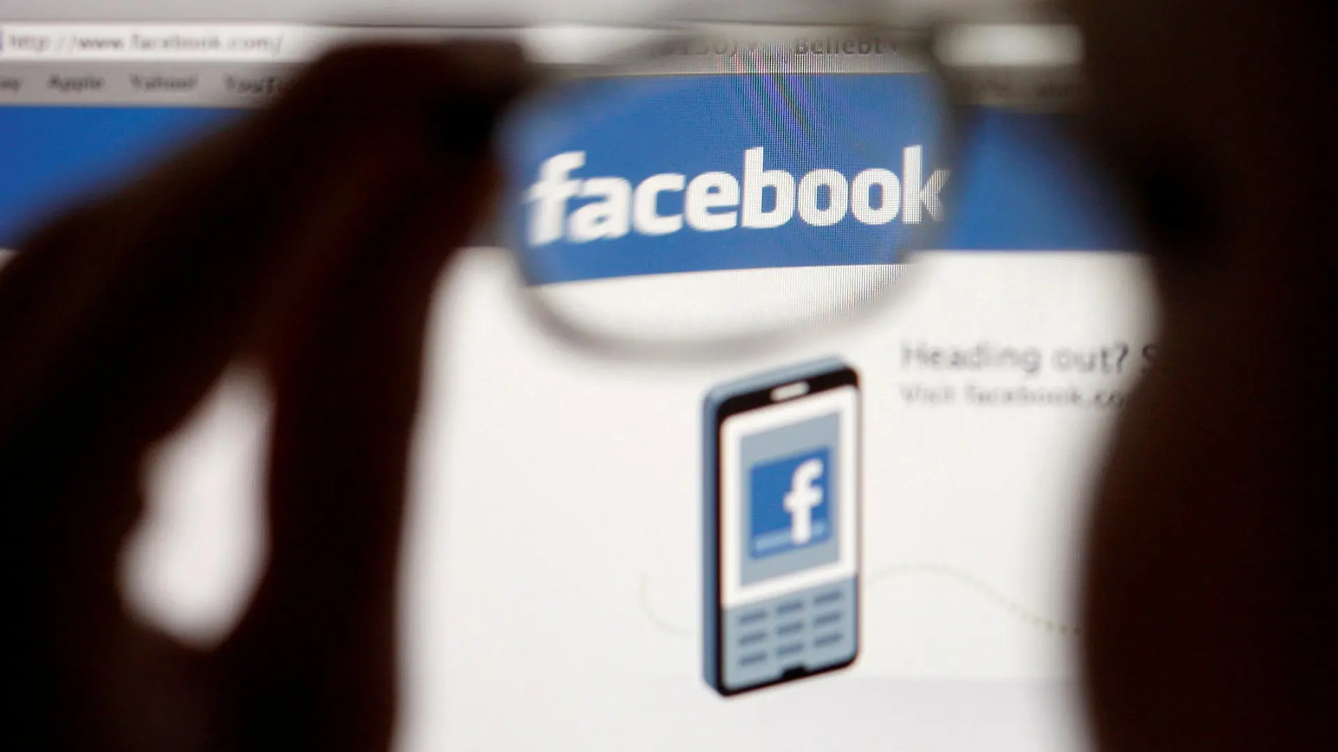 FILE PHOTO: In this photo illustration, a Facebook logo on a computer screen is seen through glasses held by a woman in Bern May 19, 2012. Picture taken May 19, 2012. REUTERS/Thomas Hodel/File Photo