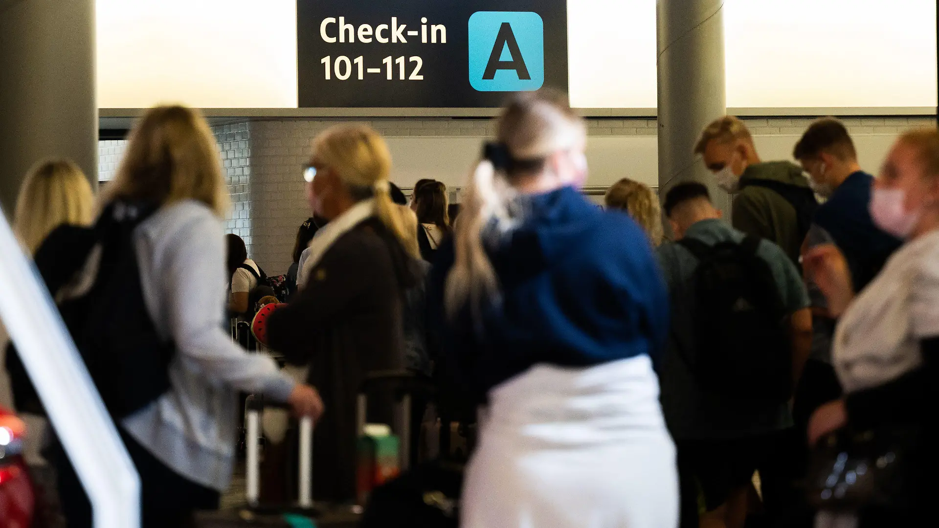 ARCHIV - 21.07.2021, Niedersachsen, Hannover: Menschen warten am Flughafen Hannover beim Check-In auf ihre Anmeldung. Derzeit brauchen Flugreisende viel Geduld. Bei den Sicherheitskontrollen am Flughafen Hannover kommt es zu langen Wartezeiten. (zu dpa: «Lange Wartezeit am Flughafen Hannover - Bundespolizei plant Taskforce») Foto: Julian Stratenschulte/dpa +++ dpa-Bildfunk +++