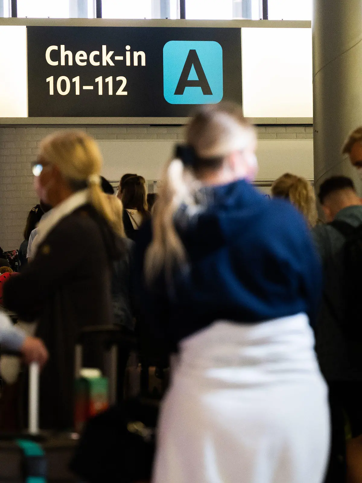 ARCHIV - 21.07.2021, Niedersachsen, Hannover: Menschen warten am Flughafen Hannover beim Check-In auf ihre Anmeldung. Derzeit brauchen Flugreisende viel Geduld. Bei den Sicherheitskontrollen am Flughafen Hannover kommt es zu langen Wartezeiten. (zu dpa: «Lange Wartezeit am Flughafen Hannover - Bundespolizei plant Taskforce») Foto: Julian Stratenschulte/dpa +++ dpa-Bildfunk +++