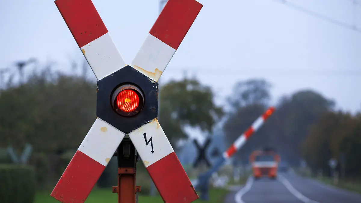 Die Warnlampe leuchtet am 16.10.2014 in der Nähe von Schwerin (Mecklenburg-Vorpommern) in einem Andreaskreuz an einem Bahnübergang. Der Streik der Gewerkschaft GDL ist in den frühen Morgenstunden beendet worden, der Zugverkehr in Norddeutschland läuft weitestgehend normal. Foto: Jens Büttner/dpa +++(c) dpa - Bildfunk+++