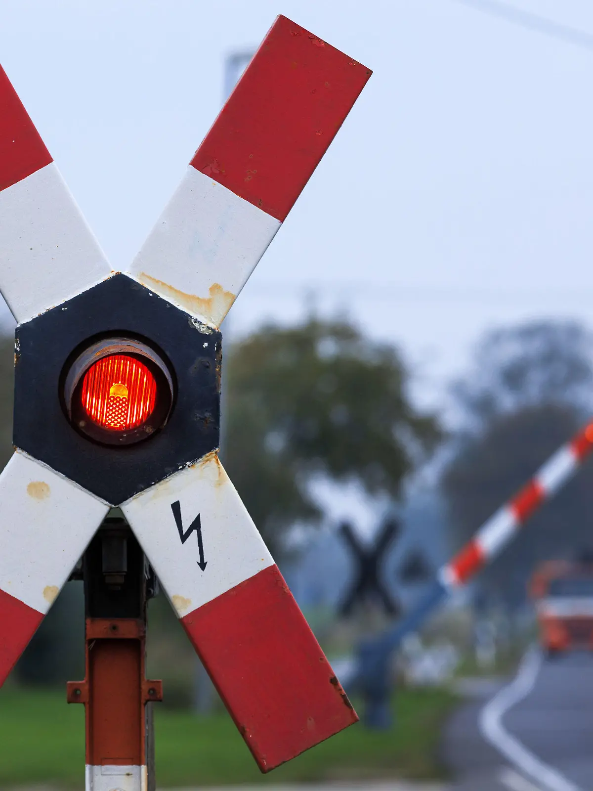 Die Warnlampe leuchtet am 16.10.2014 in der Nähe von Schwerin (Mecklenburg-Vorpommern) in einem Andreaskreuz an einem Bahnübergang. Der Streik der Gewerkschaft GDL ist in den frühen Morgenstunden beendet worden, der Zugverkehr in Norddeutschland läuft weitestgehend normal. Foto: Jens Büttner/dpa +++(c) dpa - Bildfunk+++