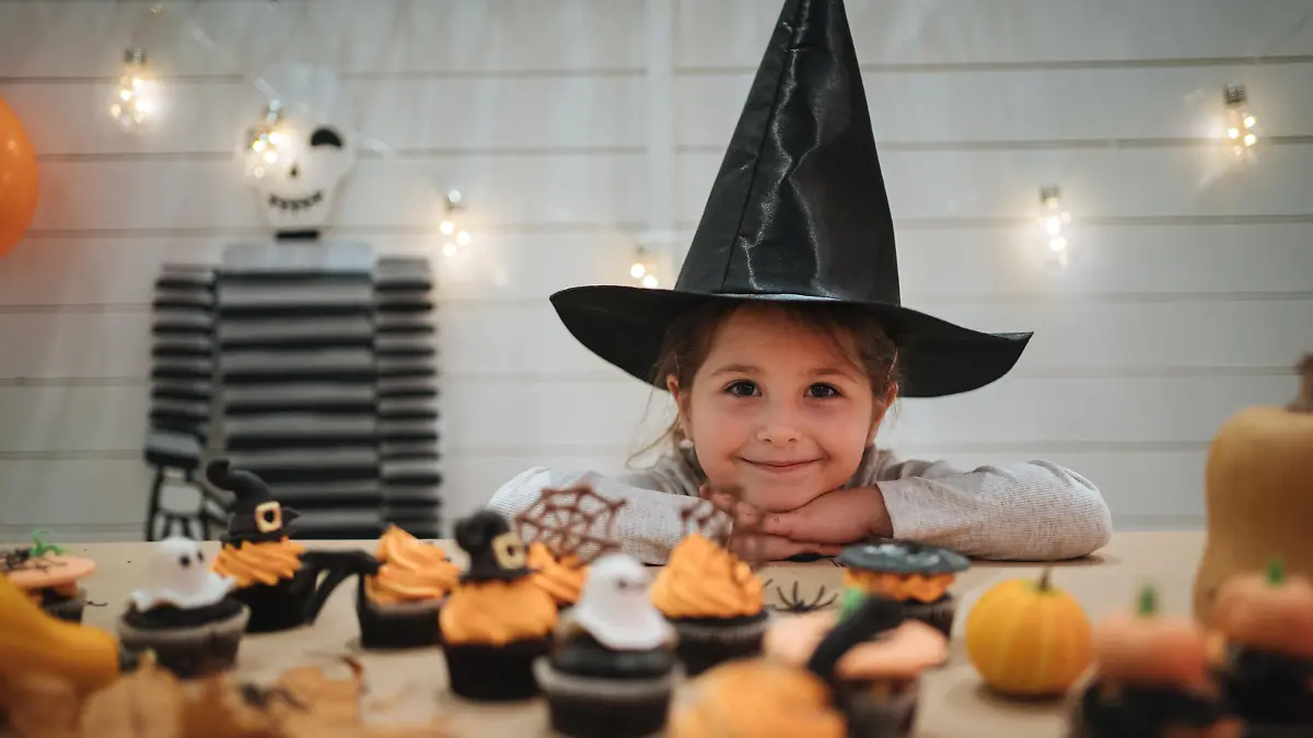 Little girl decorating her home during Halloween night