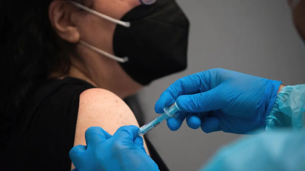 May 5, 2021, Malaga, Spain: A woman wearing a face mask as a precaution against the spread of covid-19 is being vaccinated by a health worker inside a cubicle during a massive vaccination at Fair and Congresses Palace..Health regional authorities have retimed again the vaccination with doses of Pfizer BioNTech inside large and secure places following all protective measures, as part of massive vaccination One million plan after the announcement of Andalusian government to inoculate around 600.000 vaccines during the week. Malaga Spain - ZUMAs197 20210505_zaa_s197_022 Copyright: xJesusxMeridax 