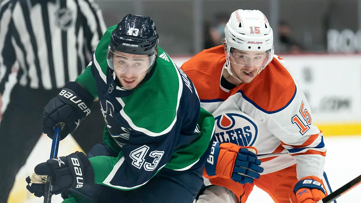 ARCHIV - 25.02.2021, Kanada, Vancouver: Eishockey: Quinn Hughes (l) von den Vancouver Canucks gegen Josh Archibald von den Edmonton Oilers. NHL-Eishockeyprofi Archibald von den Edmonton Oilers fällt wegen einer Herzmuskelentzündung für unbestimmte Zeit aus. (Zu dpa: "Nach Corona: Draisaitl-Teamkollege hat Herzmuskelentzündung") Foto: Jonathan Hayward/The Canadian Press/AP/dpa +++ dpa-Bildfunk +++