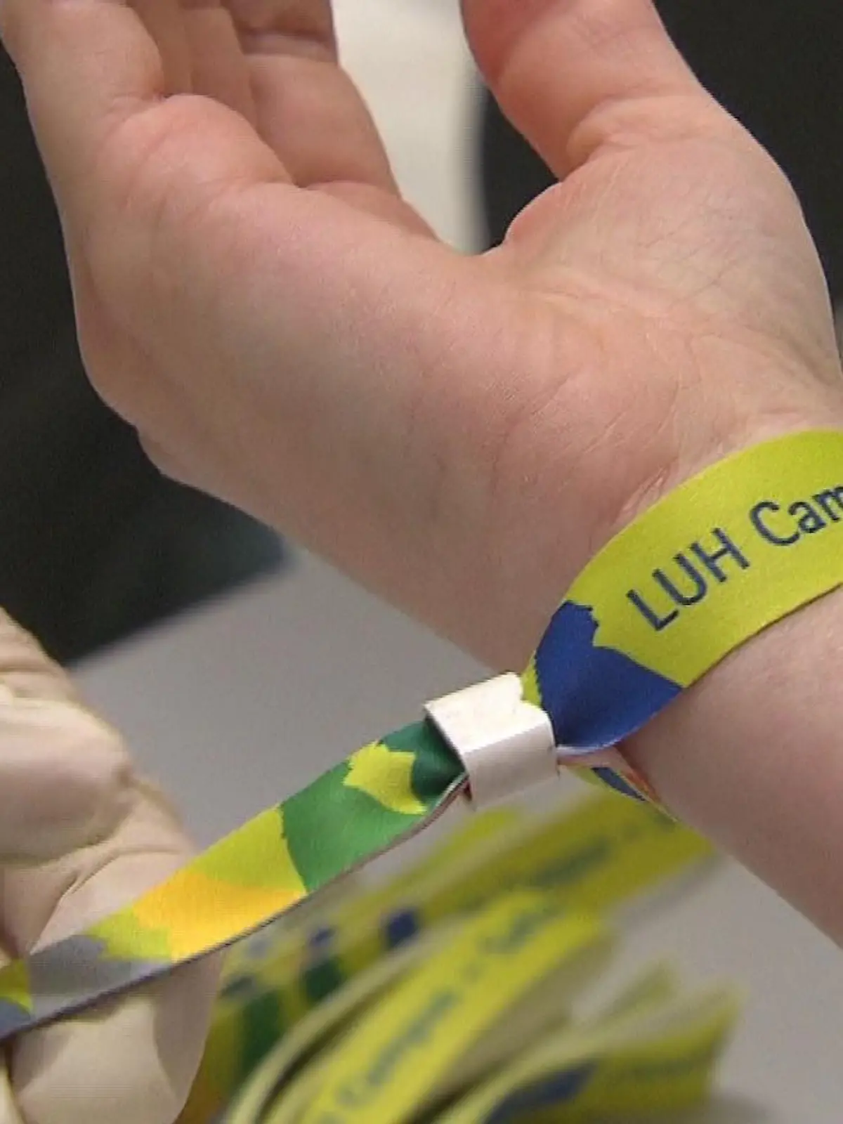 Einer Studentin an der Leibniz Universität Hannover wird ein Armband als Impfnachweis angelegt.