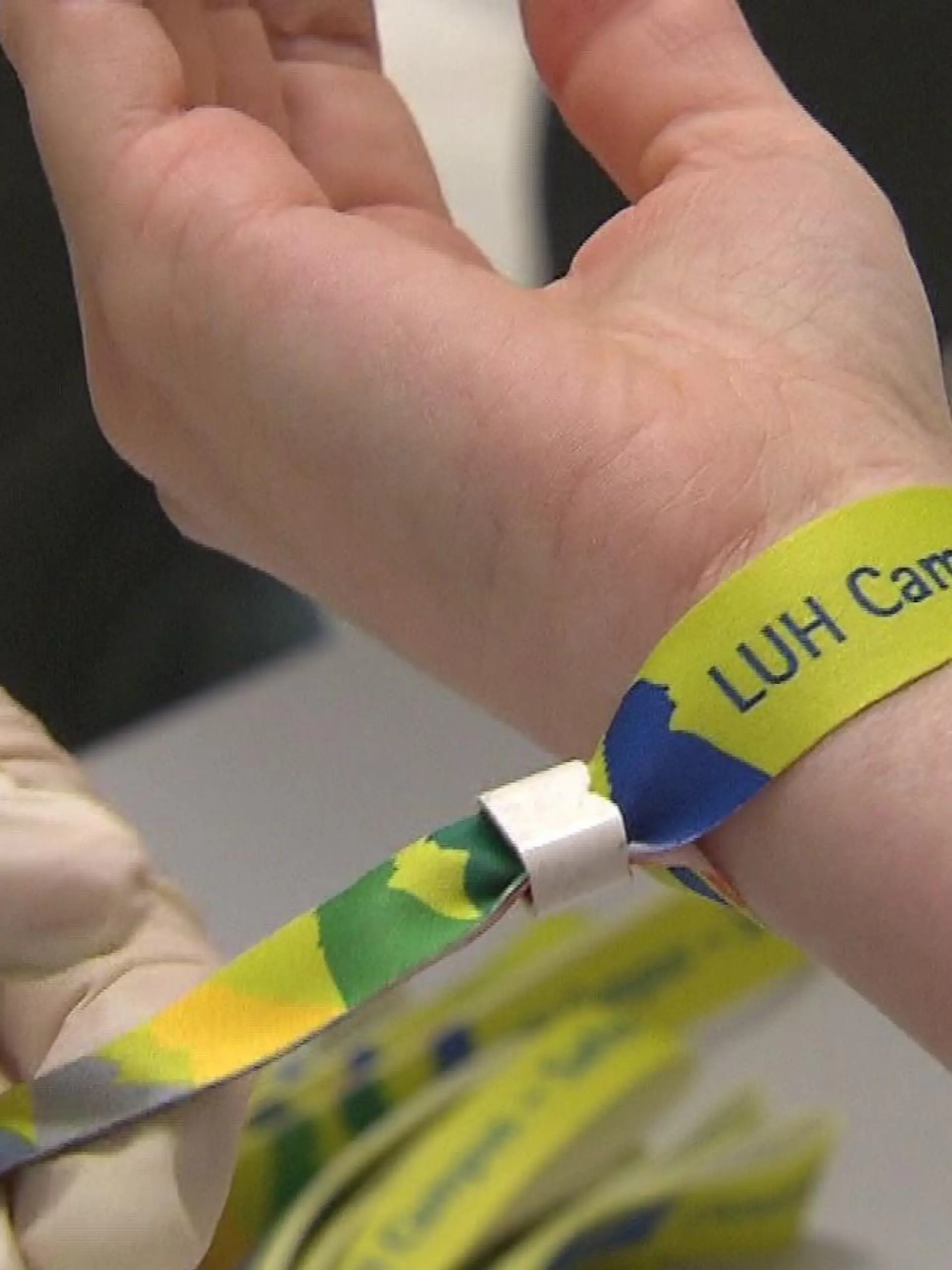 Einer Studentin an der Leibniz Universität Hannover wird ein Armband als Impfnachweis angelegt.