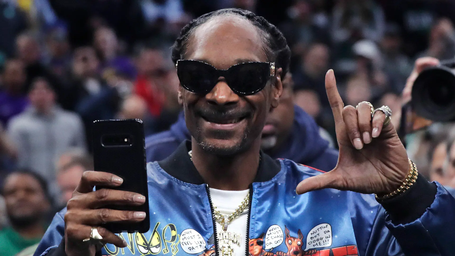 ARCHIV - 20.01.2020, USA, Boston: Rapper Snoop Dogg gestikuliert vor der ersten Hälfte eines NBA-Basketballspiels zwischen den Boston Celtics und den Los Angeles Lakers. Gleich fünf Musikgrößen, darunter die Rapper Snoop Dogg und Eminem, sollen beim 56. Super Bowl 2022 auftreten. Bei der Show in der Halbzeitpause werden auch Dr. Dre, Kendrick Lamar und die R&B-Sängerin Mary J. Blige mitwirken, teilte die Football-Liga NFL am Donnerstag mit. Foto: Charles Krupa/AP/dpa +++ dpa-Bildfunk +++