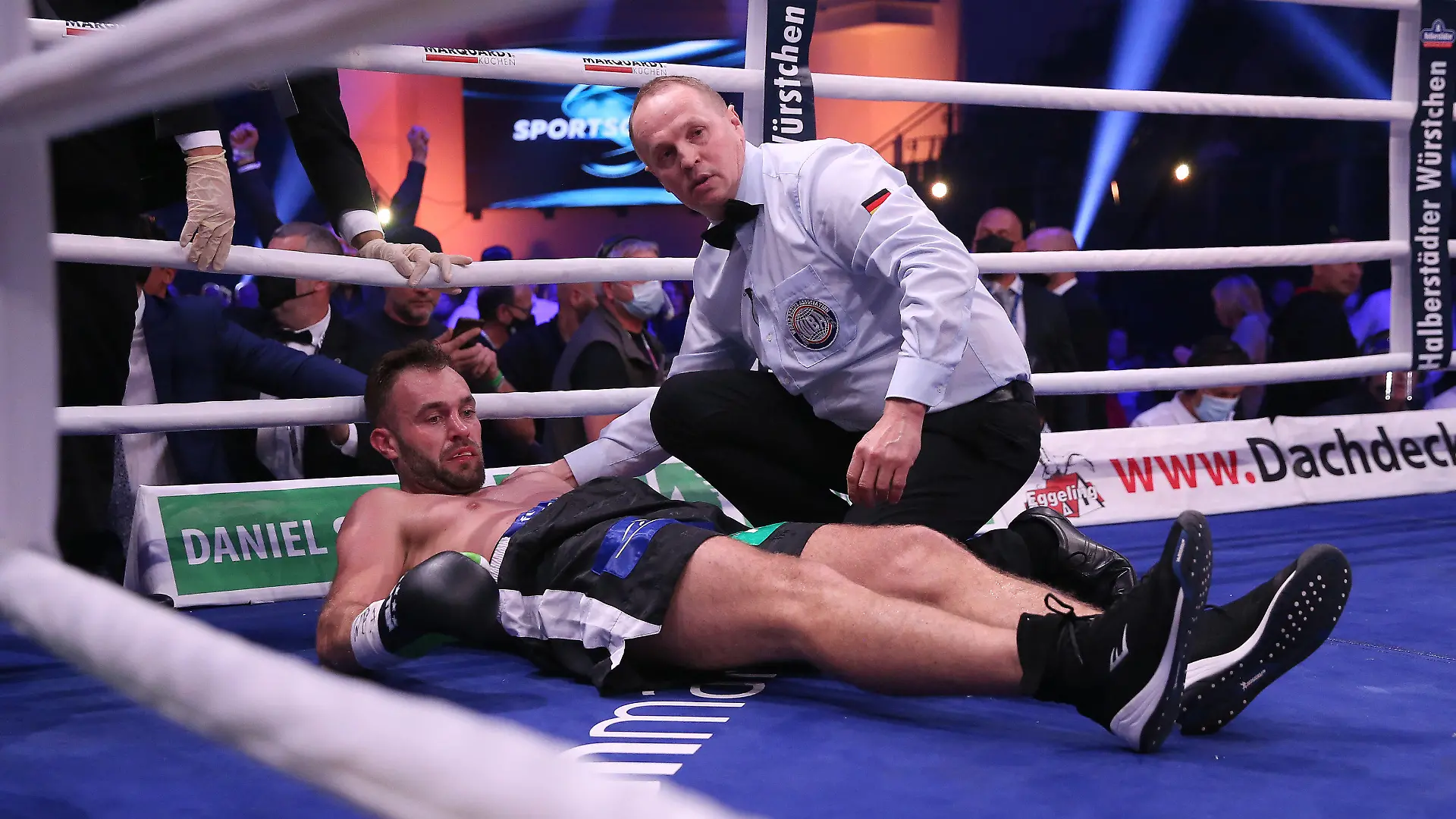 10.10.2020, Sachsen-Anhalt, Magdeburg: Boxen: WM-Kampf zwischen D. Bösel und R. Krasniqi, IBO-Weltmeisterschaft und WBA-Interims-Weltmeisterschaft im Halbschwergewicht. Dominic Bösel (l) liegt nach einem Niederschlag in der dritten Runde benommen neben Ringrichter Oliver Brien. R. Krasniqi ist durch einen überraschenden K.o.-Sieg gegen Bösel neuer Weltmeister im Halbschwergewicht. Foto: Ronny Hartmann/dpa-Zentralbild/dpa +++ dpa-Bildfunk +++
