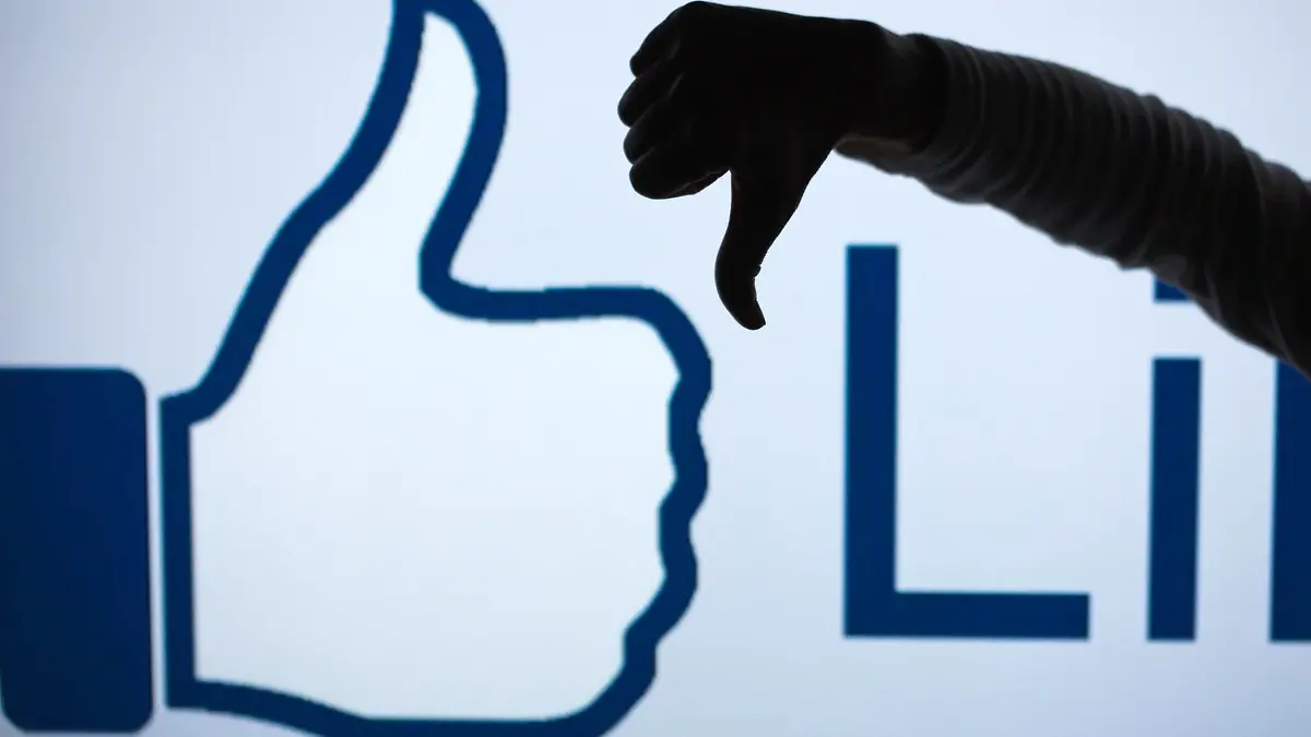 FILE - ILLUSTRATION - A woman makes the 'thumbs down' sign with her fist and thumb in front of an enlarged 'Like' symbol of the social netweorking site Facebook in Schwerin, Germany, 04 April 2013 (STAGED PICTURE). Photo: Jens Buettner/dpa (zu dpa "Zuckerberg: Facebook arbeitet an «Gefällt mir nicht»-Knopf" vom 15.09.2015) +++(c) dpa - Bildfunk+++