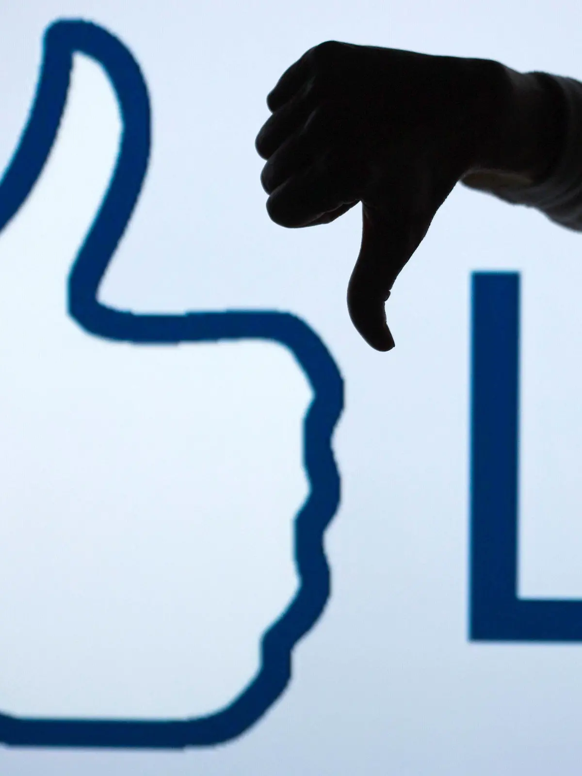 FILE - ILLUSTRATION - A woman makes the 'thumbs down' sign with her fist and thumb in front of an enlarged 'Like' symbol of the social netweorking site Facebook in Schwerin, Germany, 04 April 2013 (STAGED PICTURE). Photo: Jens Buettner/dpa (zu dpa "Zuckerberg: Facebook arbeitet an «Gefällt mir nicht»-Knopf" vom 15.09.2015) +++(c) dpa - Bildfunk+++