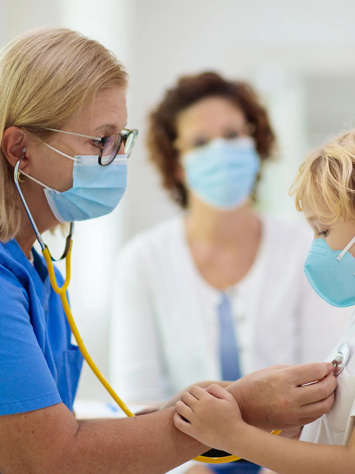 Pediatrician doctor examining sick child in face mask. Ill boy in health clinic for test and screening. Kids home treatment of virus. Coronavirus pandemic. Covid-19 outbreak. Patient coughing.