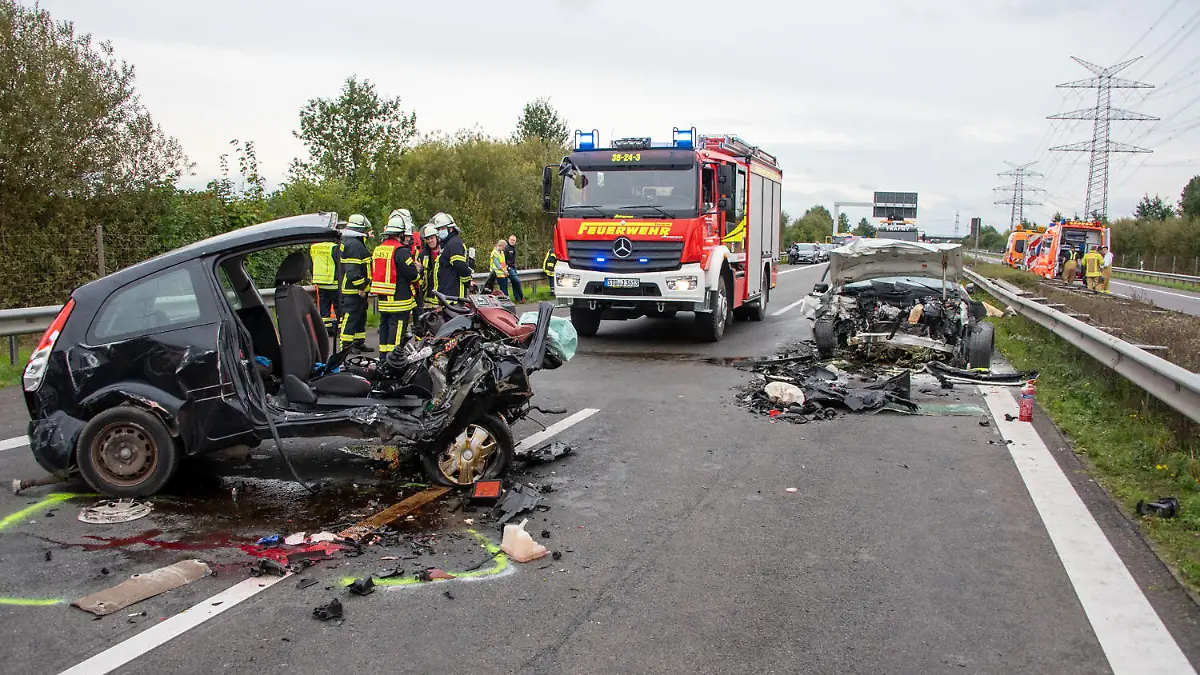 02.10.2021, Niedersachsen, Stade: Zwei zerstörte Fahrzeuge stehen auf der Autobahn 26. Bei einem Falschfahrer-Unfall auf der Autobahn 26 bei Stade sind am Samstag zwei Menschen gestorben. Nach Angaben der Polizei fuhr eine 87-Jährige an der Anschlussstelle Stade-Süd falsch auf die Autobahn. Dort stieß die Frau frontal mit dem Wagen (r) eines 48-Jährigen zusammen. Beide Fahrer wurden notärztlich behandelt, starben aber aufgrund ihrer schweren Verletzungen noch an der Unfallstelle. Foto: Joto/dpa +++ dpa-Bildfunk +++