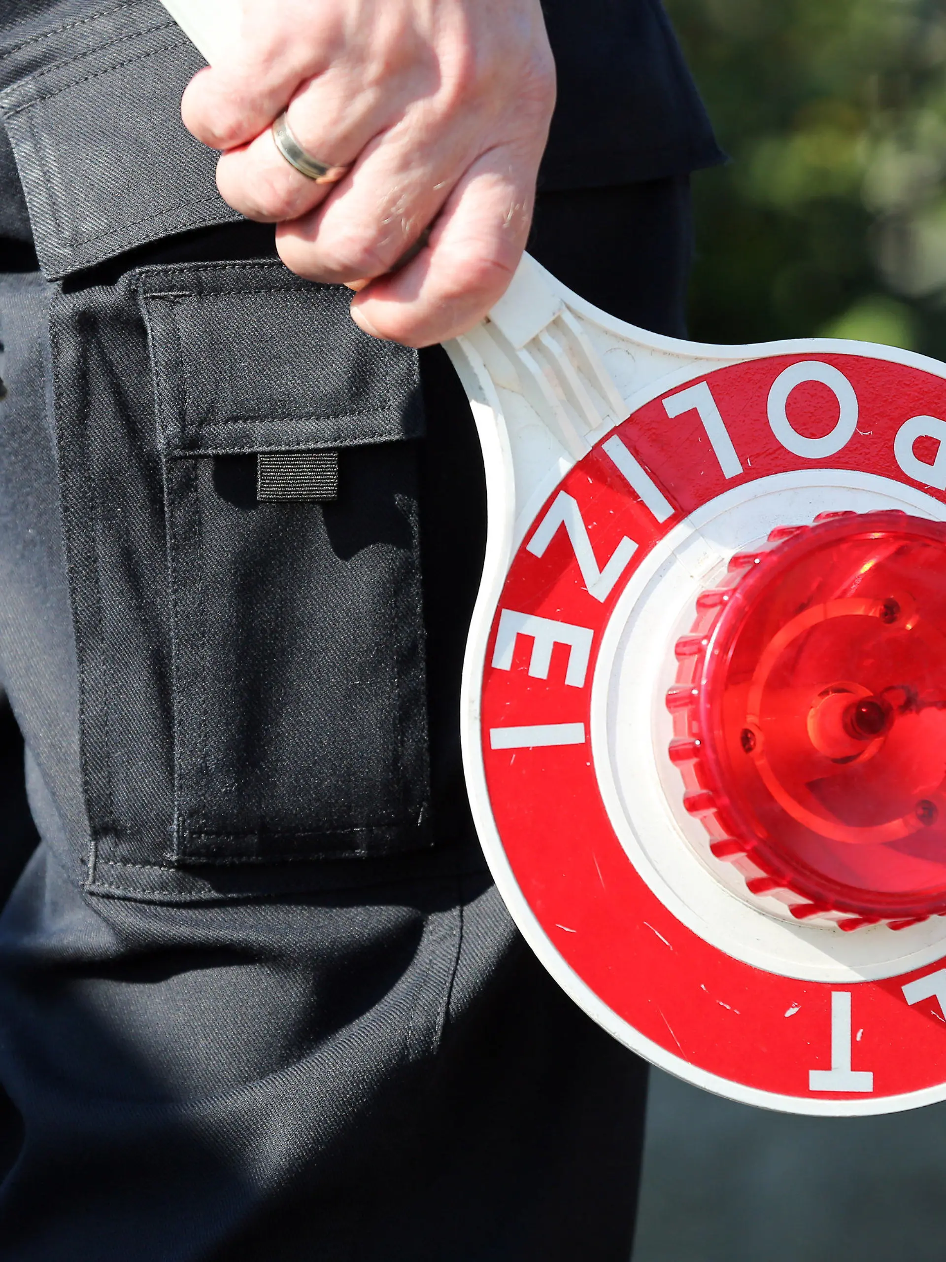 ARCHIV - Ein Polizeibeamter hält am 18.09.2014 bei einer Geschwindigkeitskontrolle in Gokel (Schleswig-Holstein) eine Polizeikelle. Schleswig-Holsteins Landespolizei kontrolliert in der nächsten Woche Autofahrer gezielt auf Alkohol und Drogen. Die von Montag bis Sonntag laufende Aktion sei europaweit abgestimmt, erklärte das Landespolizeiamt. (zu dpa «Polizei geht ab Montag Alkohol- und Drogensündern auf die Spur» vom 12.12.2016) +++(c) dpa - Bildfunk+++