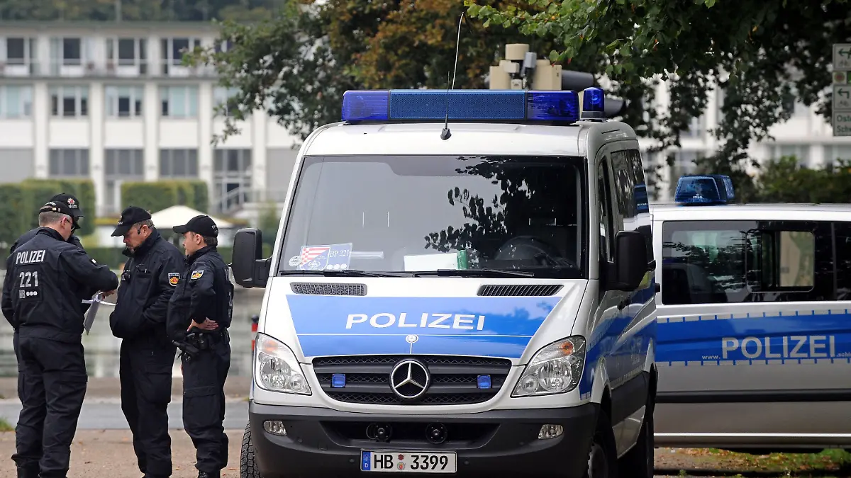 Zwischen dem Parkhotel (im Hintergrund) und der Bremen Arena in Bremen besprechen Polizeibeamte am Freitag (01.10.2010) über ihren Einsatzplan. Am 02. und 03. Oktober findet in der Hansestadt die Großveranstaltung zu "20 Jahre Deutsche Einheit" statt. In der Bremen Arena werden am Sonntag (03.10.2010) die deutschen Verfassungsorgane und internationale Gäste zum offiziellen Teil der Feierlichkeiten erwartet. Foto: Ingo Wagner dpa/lni  +++(c) dpa - Bildfunk+++