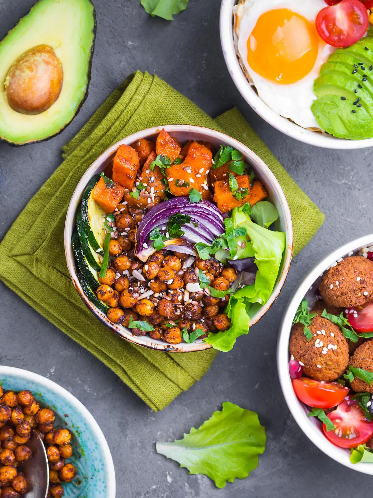 Mixed healthy vegetarian salads with vegetables, sweet potato, falafel, bulgur, avocado, eggs. Assorted buddha bowl salads. Vegetarian food. Healthy lunch/dinner. Salad in bowl. Ingredients for making