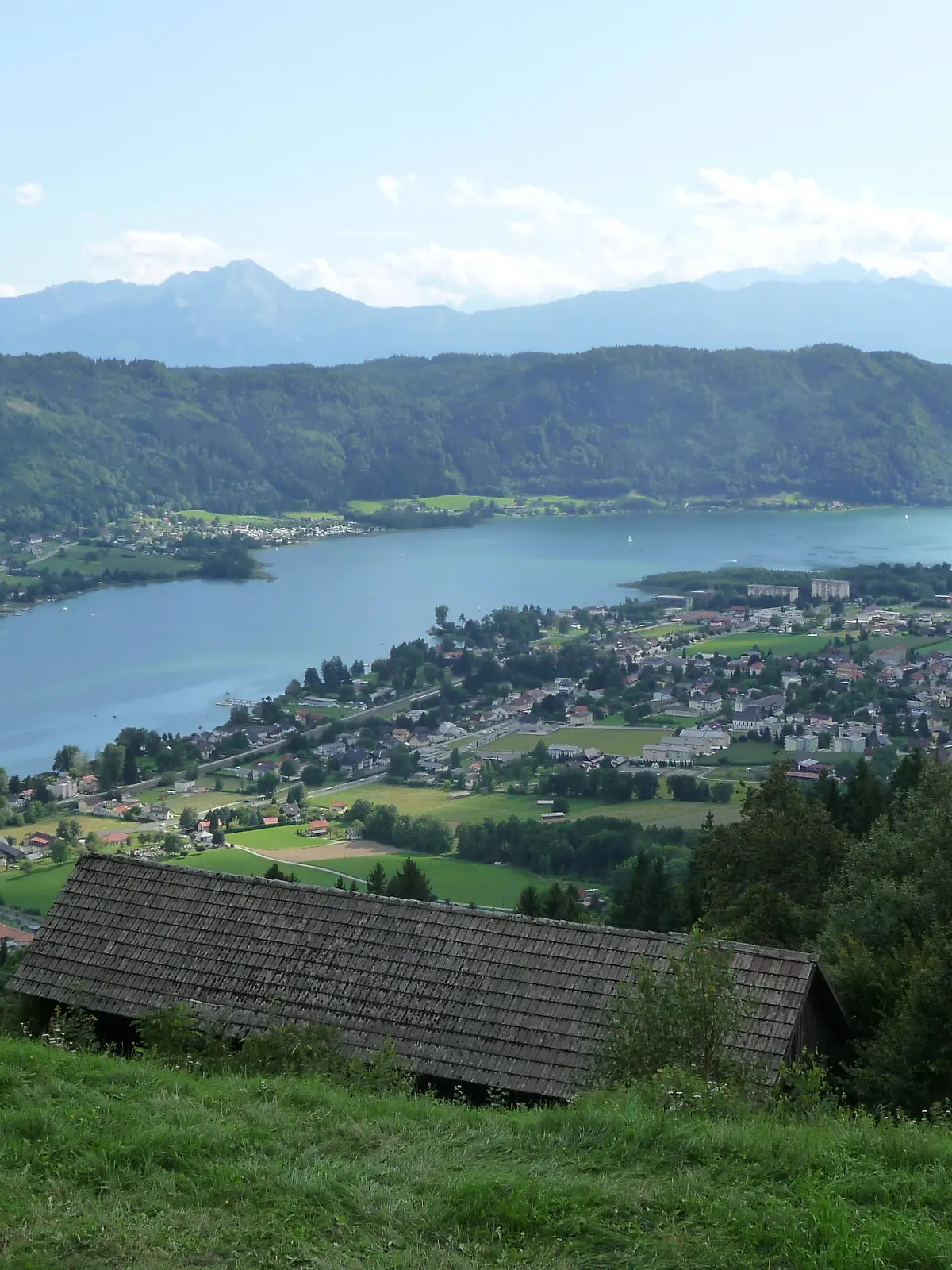Blick auf den Ossiacher See hoch ueber Bodensdorf in Kaernten, Oesterreich, aufgenommen am 15.08.2019. Im Hintergrund die Ossiacher Tauern und die Karawanken. Foto: Beate Schleep