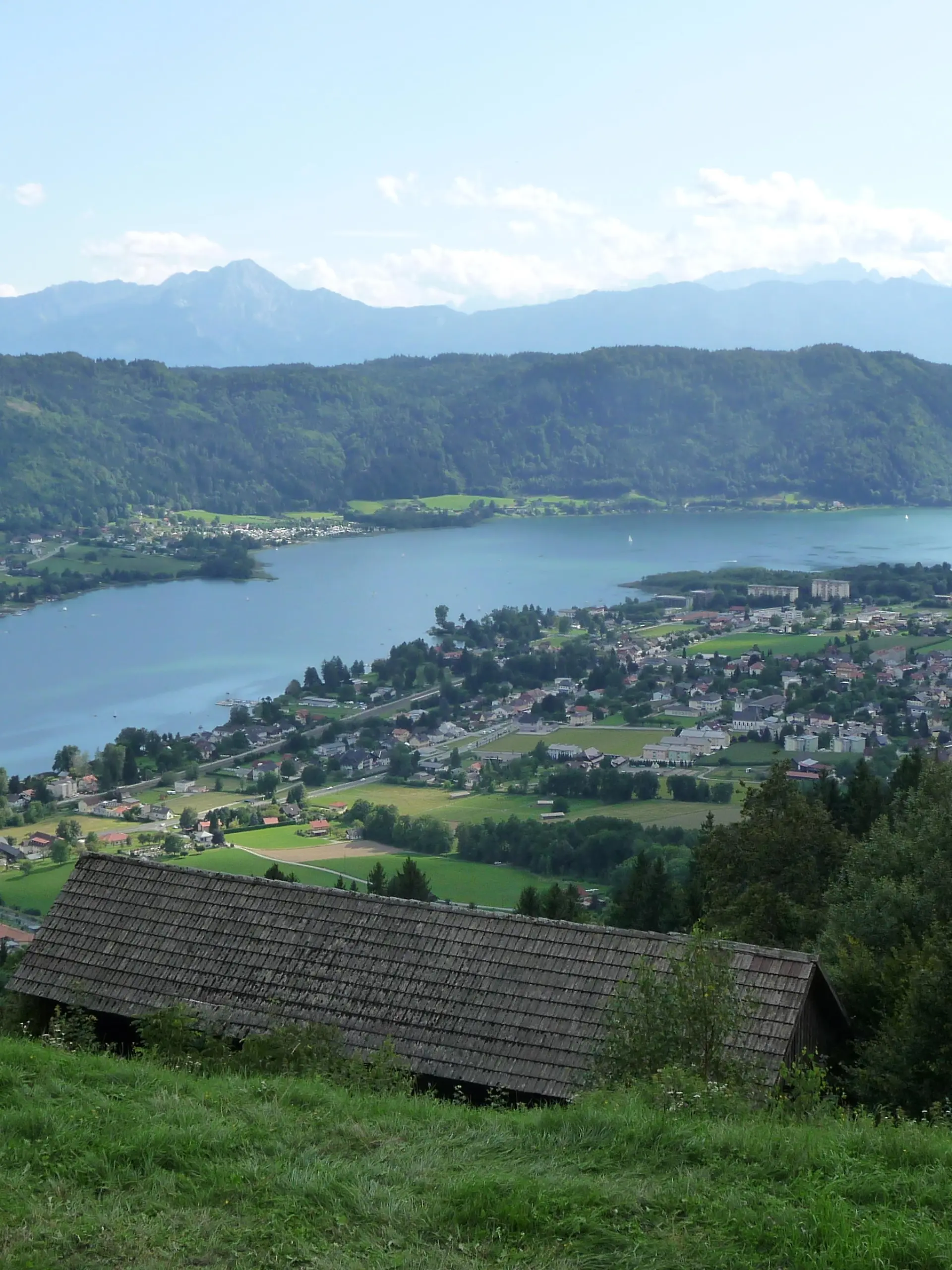 Blick auf den Ossiacher See hoch ueber Bodensdorf in Kaernten, Oesterreich, aufgenommen am 15.08.2019. Im Hintergrund die Ossiacher Tauern und die Karawanken. Foto: Beate Schleep