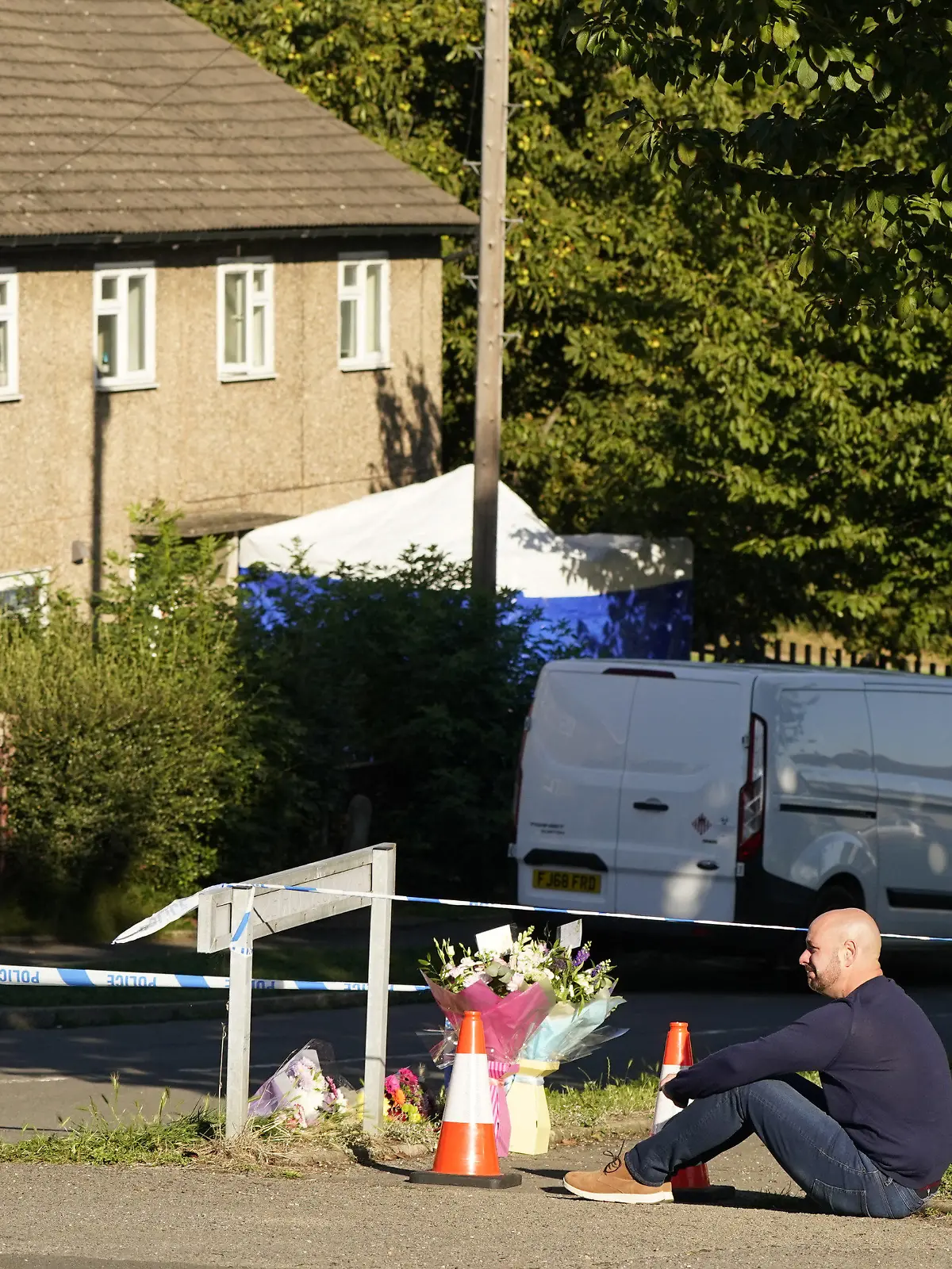 20.09.2021, Großbritannien, Killamesh: Der Vater zweier der Opfer legt Blumen am Tatort in Chandos Crescent in der Nähe von Sheffield, wo am 19.09.2021 eine Frau und drei Kinder, zwei davon ihre eigenen, in einem Haus tot aufgefunden wurden, ab. Die Polizei von Derbyshire teilte mit, dass sich ein Mann in Polizeigewahrsam befindet und im Zusammenhang mit den Todesfällen nicht nach weiteren Personen gesucht wird. Foto: Danny Lawson/PA Wire/dpa +++ dpa-Bildfunk +++