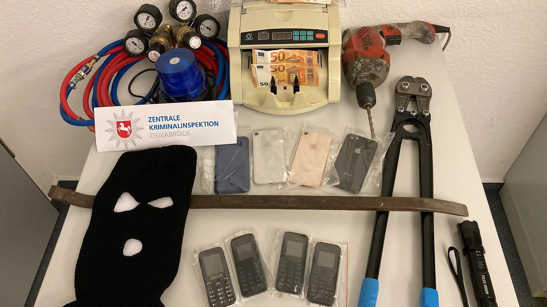 Am vergangenen Dienstag stellten deutsch-niederländische Ermittler zahlreiche Gegenstände bei er Durchsuchungsaktion sicher. Darunter auch eine Geldzählmaschine, über 20 Handys sowie Bargeld in vierstelliger Höhe.
Bild: Polizei