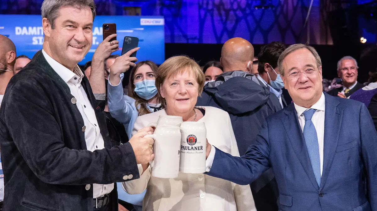 dpatopbilder - 24.09.2021, Bayern, München: Beim offiziellen Wahlkampfabschluss von CDU und CSU in der Festhalle am Nockherberg stoßen Armin Laschet (r-l), Kanzlerkandidat der Union, CDU-Parteivorsitzender und Ministerpräsident von Nordrhein-Westfalen, Bundeskanzlerin Angela Merkel (CDU) und Markus Söder, CSU-Parteivorzitzender und Ministerpräsident von Bayern, mit Bierkrügen an. Foto: Matthias Balk/dpa +++ dpa-Bildfunk +++