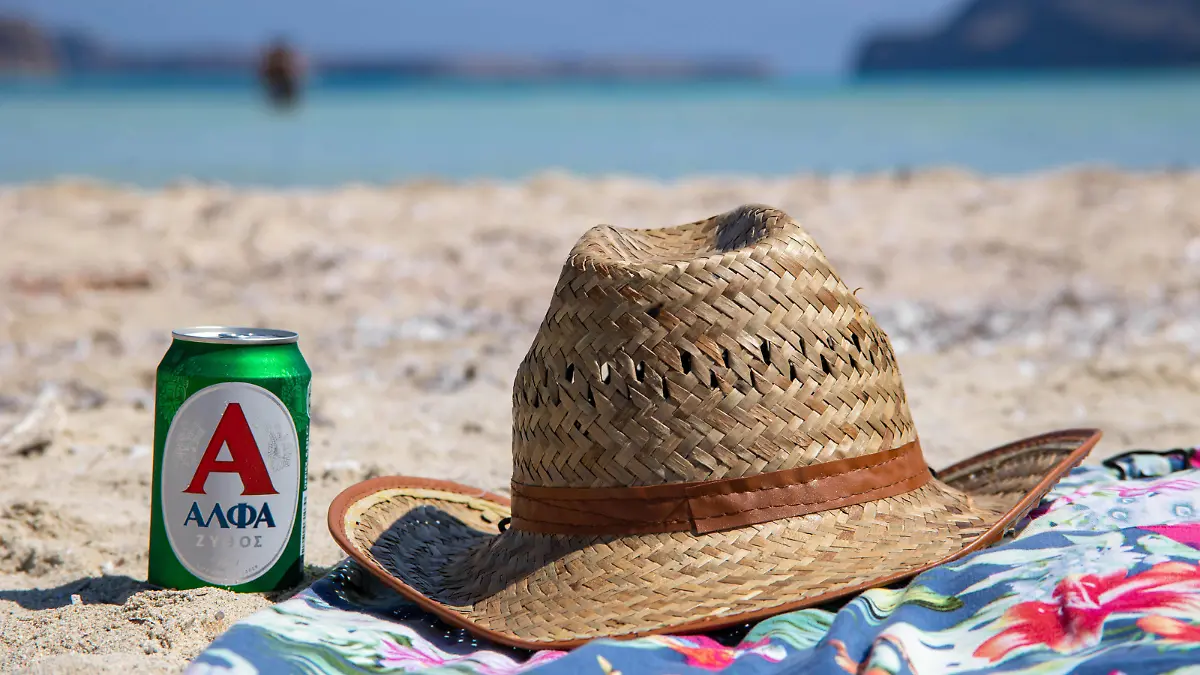 Tourism In Greece - Famous Balos Beach In Crete Island A hat and a beer on a towel on the sand of Balos Beach, the incredible lagoon with the turquoise exotic and tropical water of the Mediterranean sea is located in Chania region in Crete Island. Balos is one of the most visited beaches in Crete and popular for visitors around the world. Crystal clear water, the lagoon, rocky steep mountains, a beach bar providing umbrellas and shadow with beverages and a pirate island are located at the same region that is accessible by a 20 min trek or boat. Greece is trying to boost its tourism and give privileges to vaccinated against Covid-19 Coronavirus pandemic international tourists and locals, as the country is heavily depended from the tourism in PUBLICATIONxNOTxINxFRA Copyright: xNicolasxEconomoux