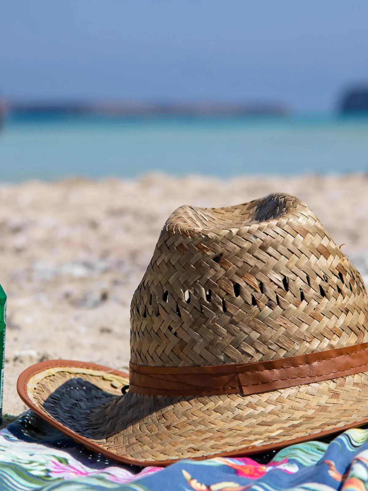 Tourism In Greece - Famous Balos Beach In Crete Island A hat and a beer on a towel on the sand of Balos Beach, the incredible lagoon with the turquoise exotic and tropical water of the Mediterranean sea is located in Chania region in Crete Island. Balos is one of the most visited beaches in Crete and popular for visitors around the world. Crystal clear water, the lagoon, rocky steep mountains, a beach bar providing umbrellas and shadow with beverages and a pirate island are located at the same region that is accessible by a 20 min trek or boat. Greece is trying to boost its tourism and give privileges to vaccinated against Covid-19 Coronavirus pandemic international tourists and locals, as the country is heavily depended from the tourism in PUBLICATIONxNOTxINxFRA Copyright: xNicolasxEconomoux 