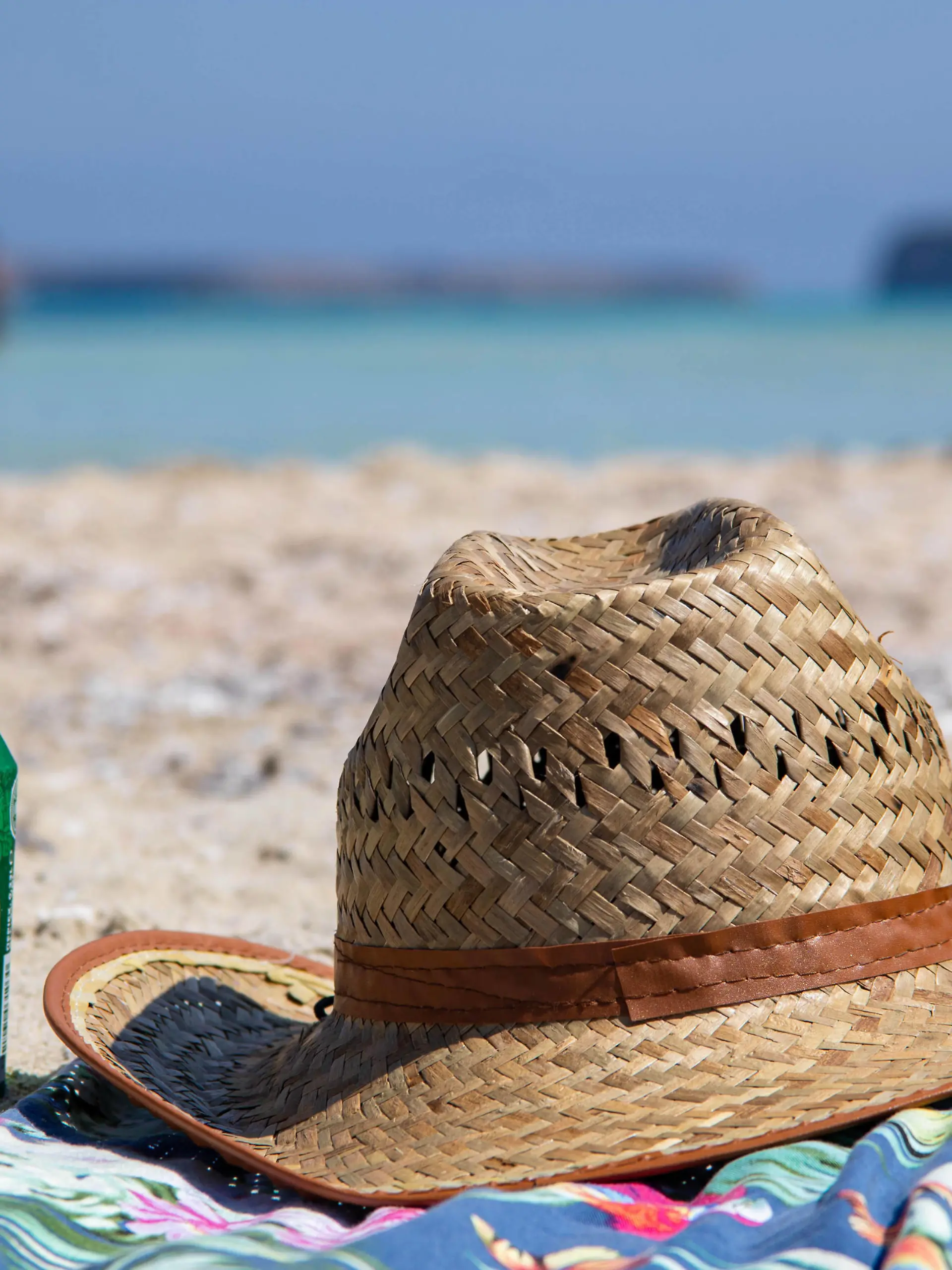 Tourism In Greece - Famous Balos Beach In Crete Island A hat and a beer on a towel on the sand of Balos Beach, the incredible lagoon with the turquoise exotic and tropical water of the Mediterranean sea is located in Chania region in Crete Island. Balos is one of the most visited beaches in Crete and popular for visitors around the world. Crystal clear water, the lagoon, rocky steep mountains, a beach bar providing umbrellas and shadow with beverages and a pirate island are located at the same region that is accessible by a 20 min trek or boat. Greece is trying to boost its tourism and give privileges to vaccinated against Covid-19 Coronavirus pandemic international tourists and locals, as the country is heavily depended from the tourism in PUBLICATIONxNOTxINxFRA Copyright: xNicolasxEconomoux 