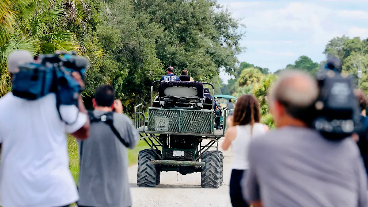 Members of the media film law enforcement as they drive swamp buggies down a dirt road on the Southside of the Carlton Reserve, while searching for any signs of Brian Laundrie, Tuesday, Sept. 21, 2021, in Venice, Fla. Search teams found nothing of note Wednesday at the Florida wilderness park where they have spent days looking for Laundrie, the boyfriend of Gabby Petito, the young woman who authorities say was killed while on a cross-country trip with him. (Andrea Melendez/Naples Daily News via AP)