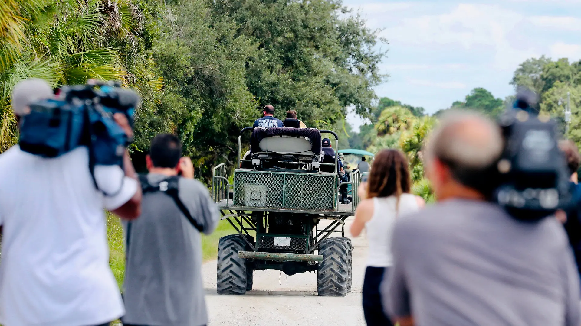 Members of the media film law enforcement as they drive swamp buggies down a dirt road on the Southside of the Carlton Reserve, while searching for any signs of Brian Laundrie, Tuesday, Sept. 21, 2021, in Venice, Fla. Search teams found nothing of note Wednesday at the Florida wilderness park where they have spent days looking for Laundrie, the boyfriend of Gabby Petito, the young woman who authorities say was killed while on a cross-country trip with him. (Andrea Melendez/Naples Daily News via AP)